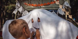 Halloween mit Kindern | Kind malt auf einem Bett-Laken ein Gespenster-Gesicht