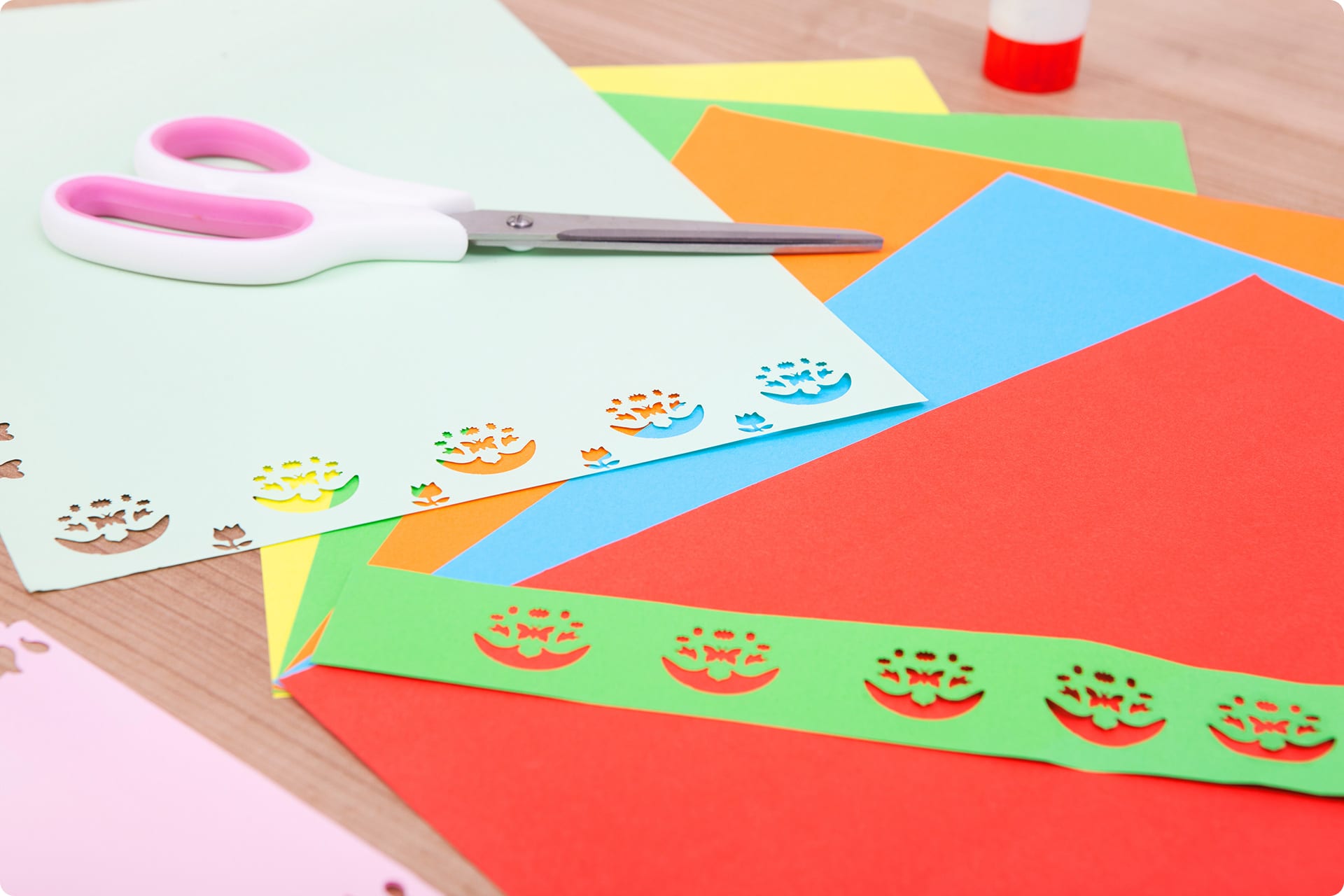 Osterkarten basteln mit Kindern | weiße Schere liegt auf weißem ausgestanzten Papier