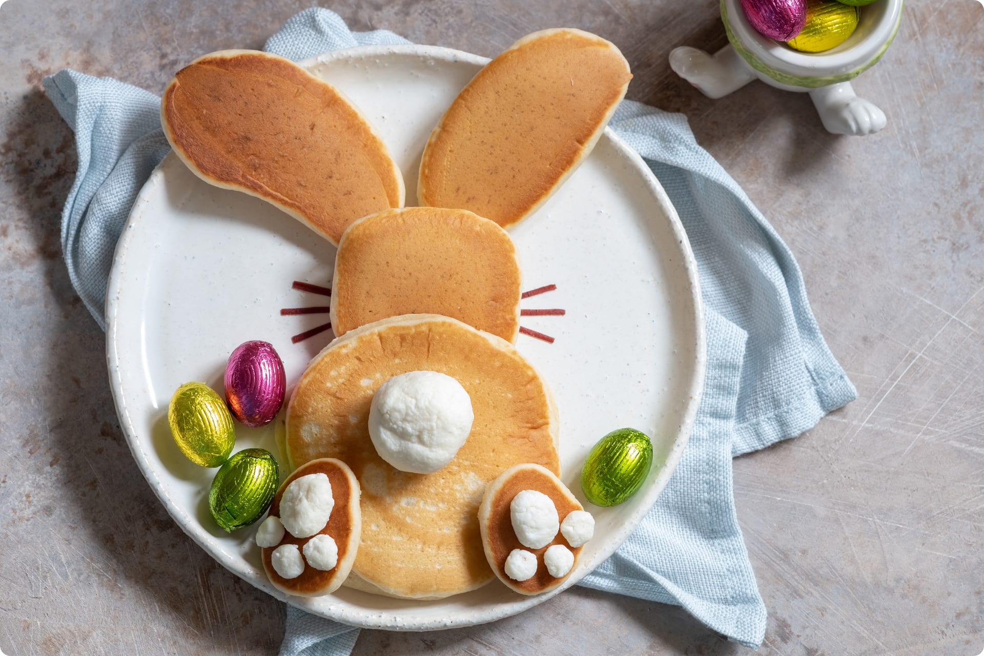 Osterrezepte für Kinder | Osterhasen aus gebackenen Teig auf Teller, mit Marshmellows und Zuckerfarbe