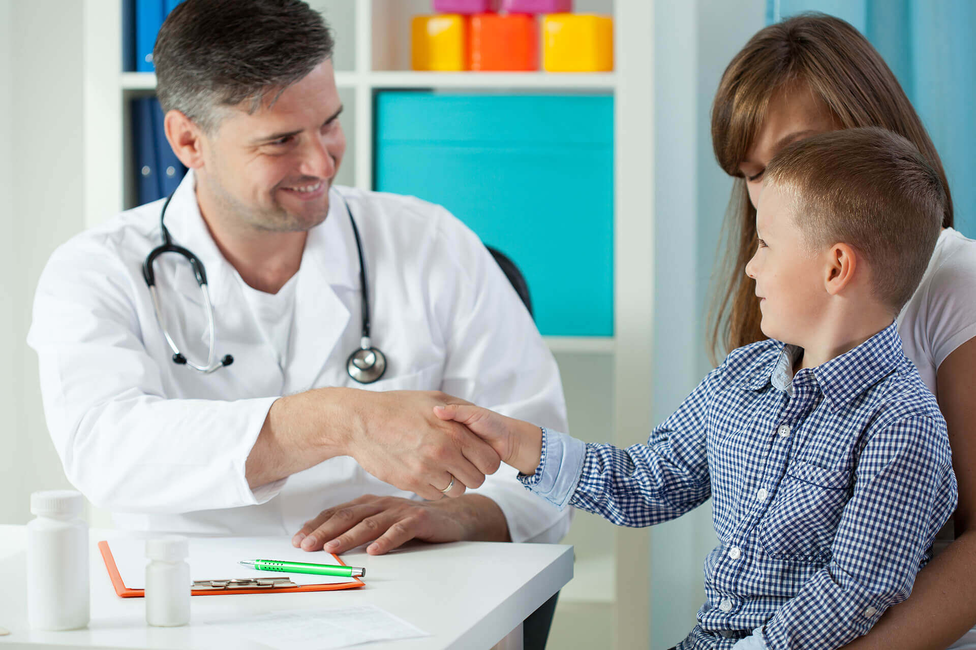 Business | Healthcare | 2 | Image | passende Lösungen | Mutter mit Kind sitzen vor einem Arzt