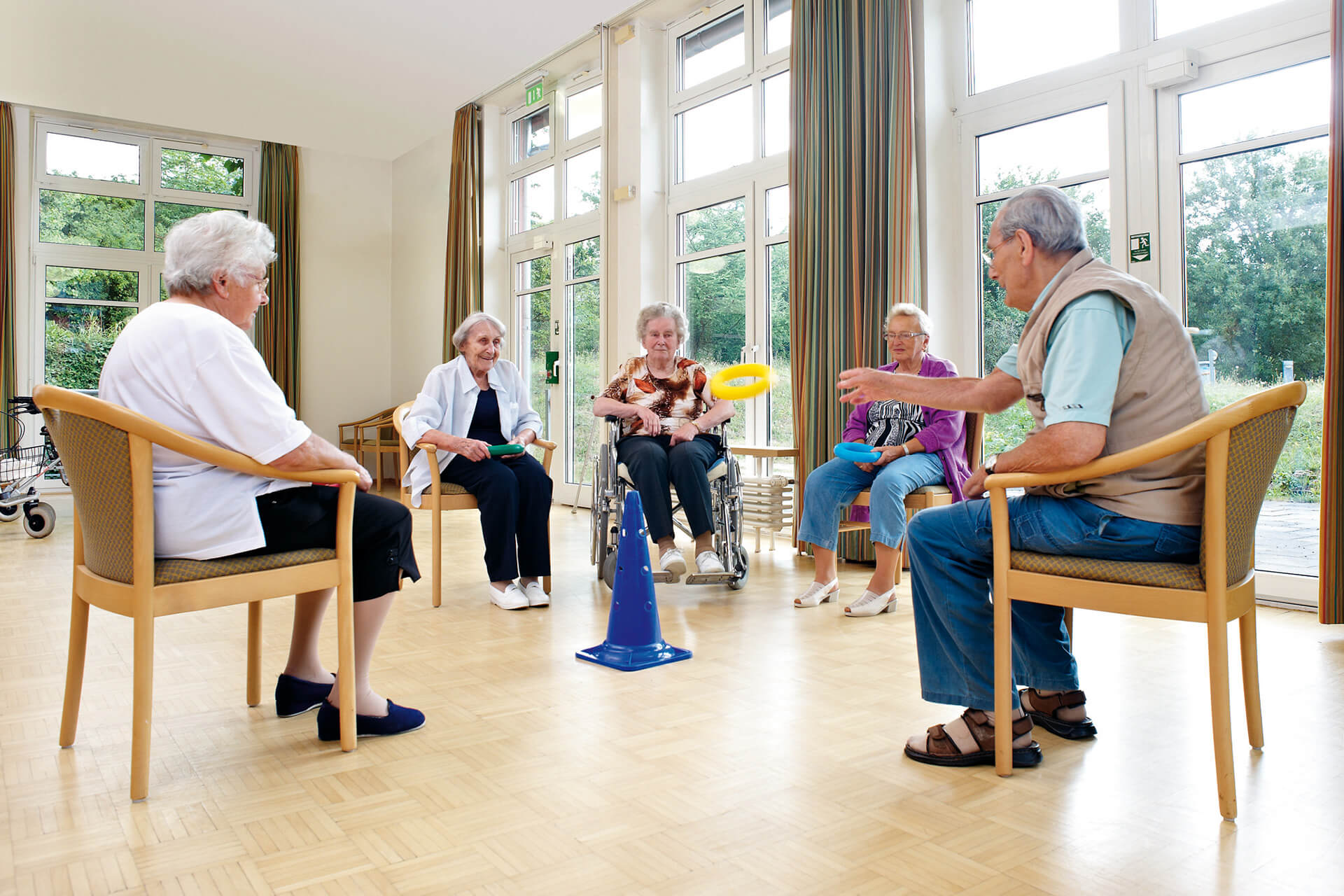 Heime | 2 | Image | Frauen und Männer sitzen im Stuhlkreis und werfen Ringe auf einen Ständer