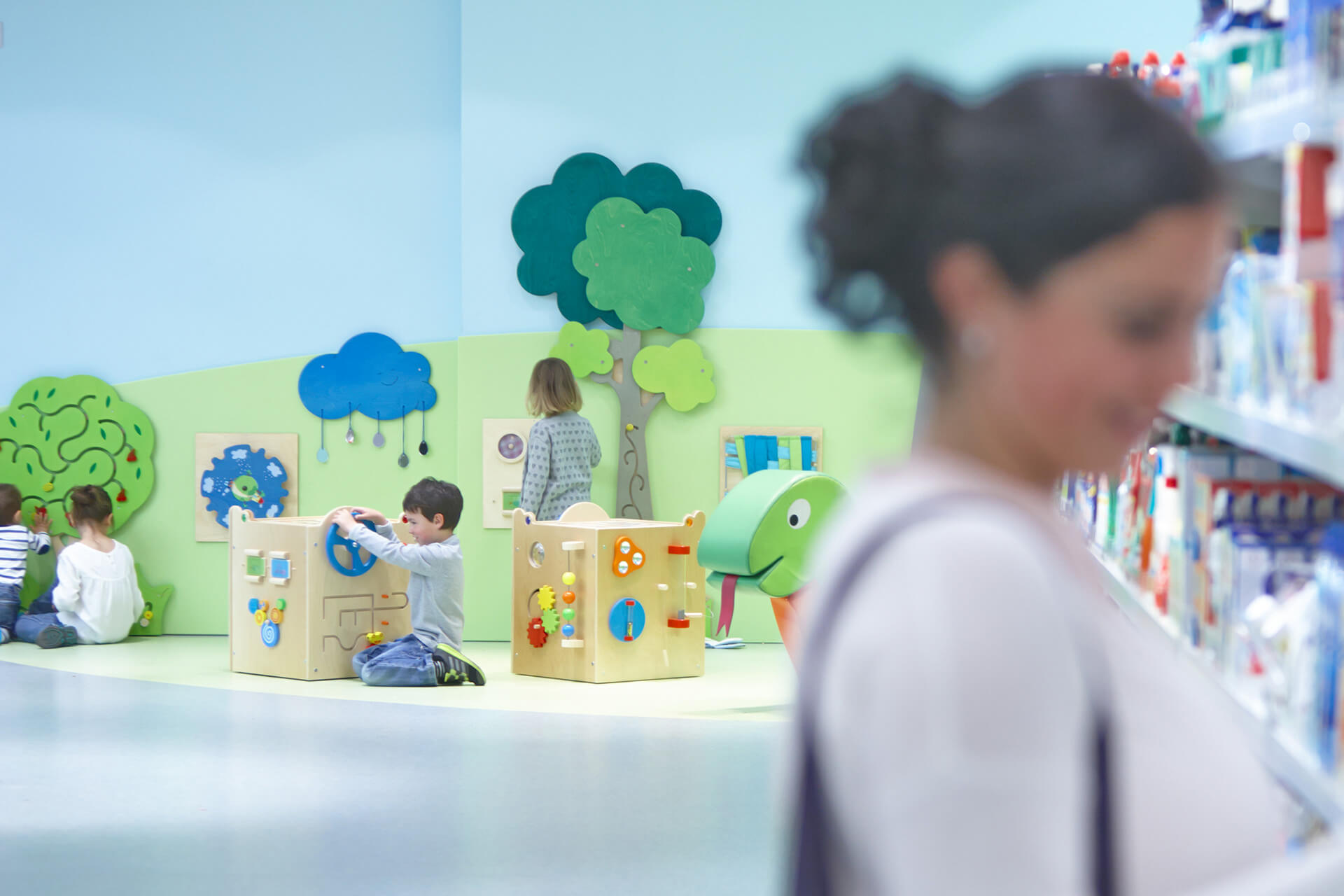 Retail | 2 | Image | Spielwürfel dm | Kind kniet vor Spielwürfel und spielt, anderes Kind steht und spiel an Wand-Bäumen