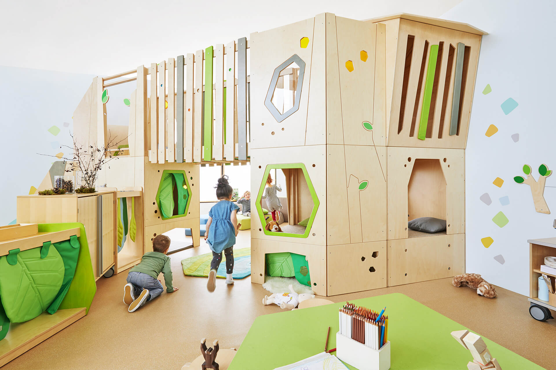 Geschäftsräume & Praxen | Indoor Spielplatz | zweistöckiger Indoorspielplatz aus Buchholzplatten mit Fenster, Zaun, Kuschelecke ausgelegt mit grünen Teppichen