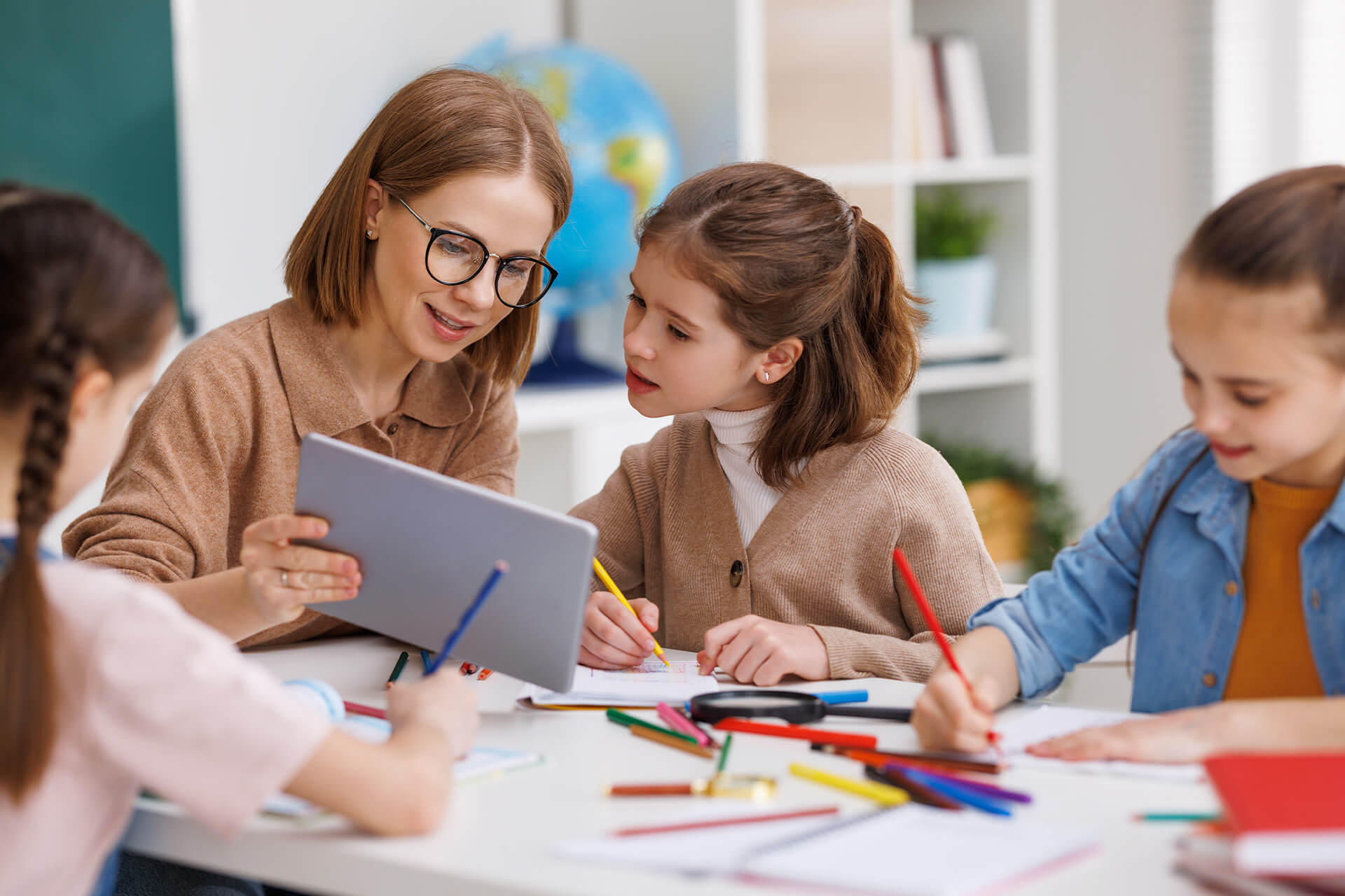 Education | Schule und Hort | Frau mit Tablet unterrichtet Kinder in der Schule