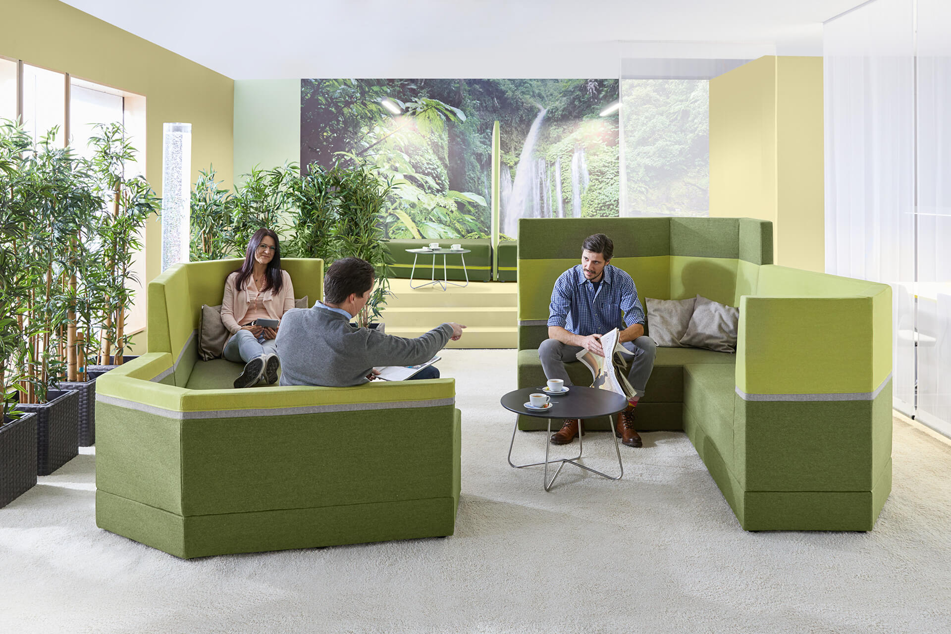 Bildung | Schule und Hort | 2 | Image | Verwaltungsräume | Frau und 2 Männer sitzen auf hellgrün - dunkelgrünen Sitzmöbel in einem Raum mit Palmen