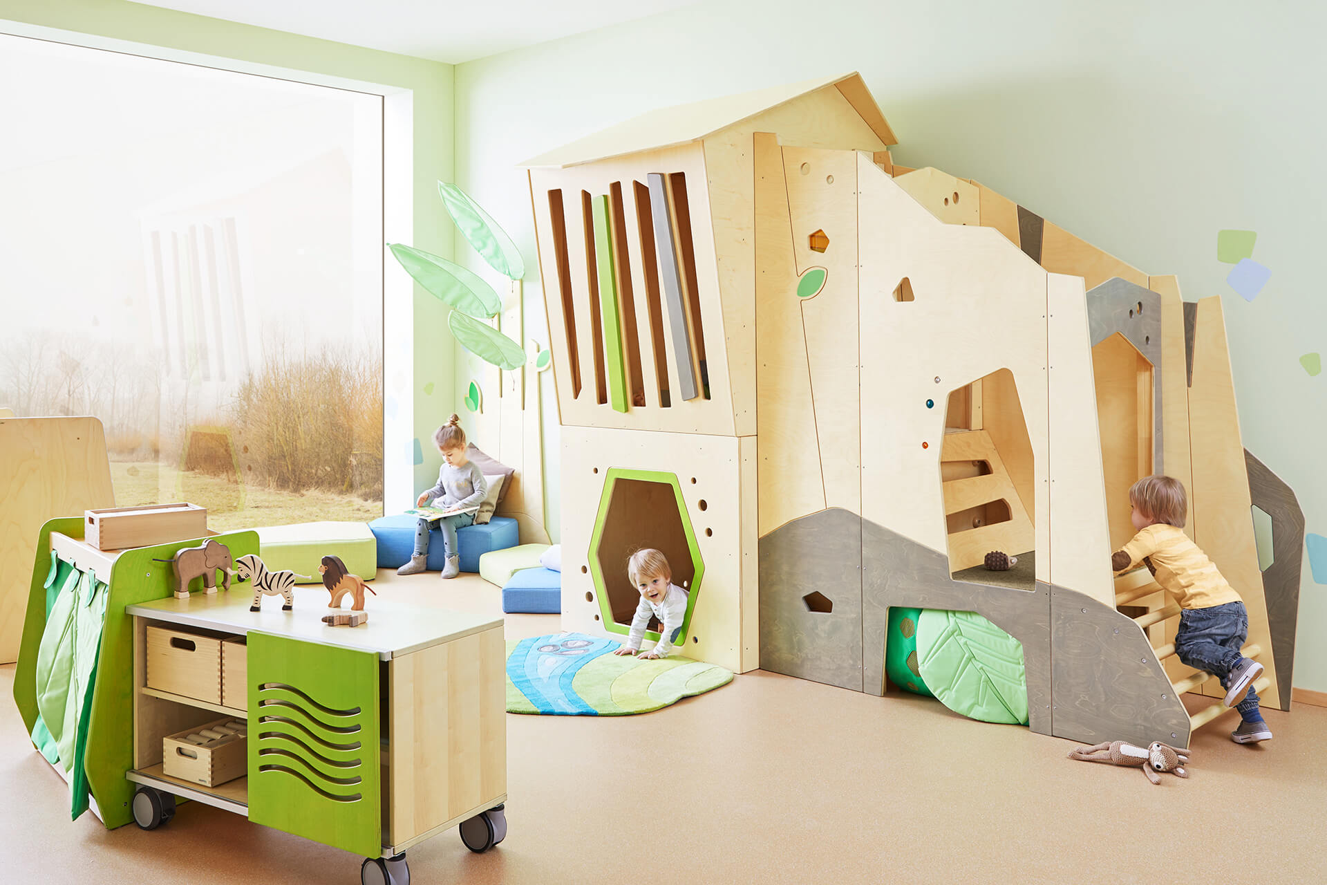 Spielraum | Spielen & Bewegung | kleine Kinder klettern in Spielhaus aus Holz, mit Leiter und Fenster, davor steht ein Materialschrank mit Spielzeug