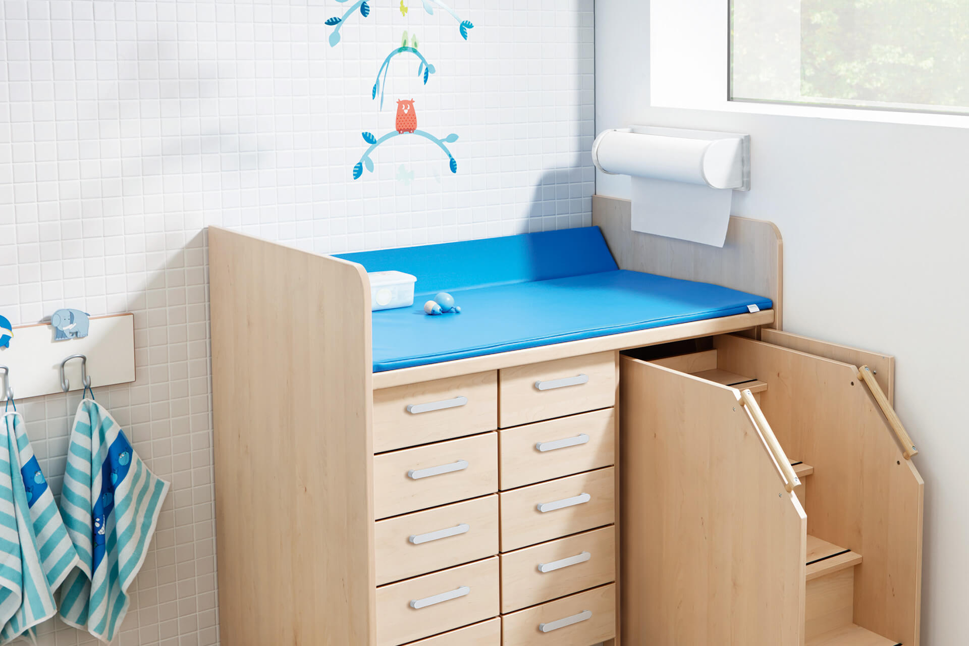 Räume | Krippe und Kindergarten | Wasch- und Wickelraum | Wickelkommode mit blauer Auflage