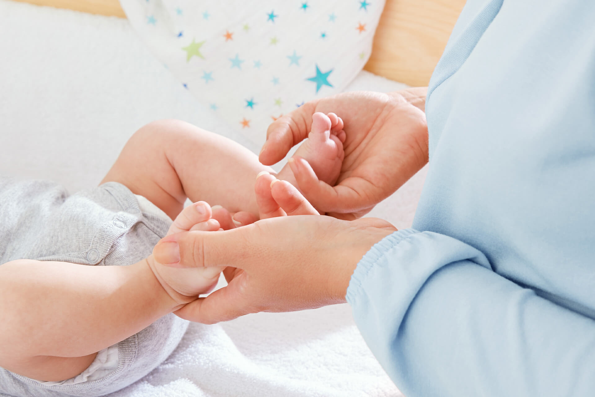 Räume | Krippe & Kindergarten | Wasch- und Wickelraum | Hygiene & Zubehör | Babyfüße werden mit Händen hochgehalten, um eine neue Windel anzulegen