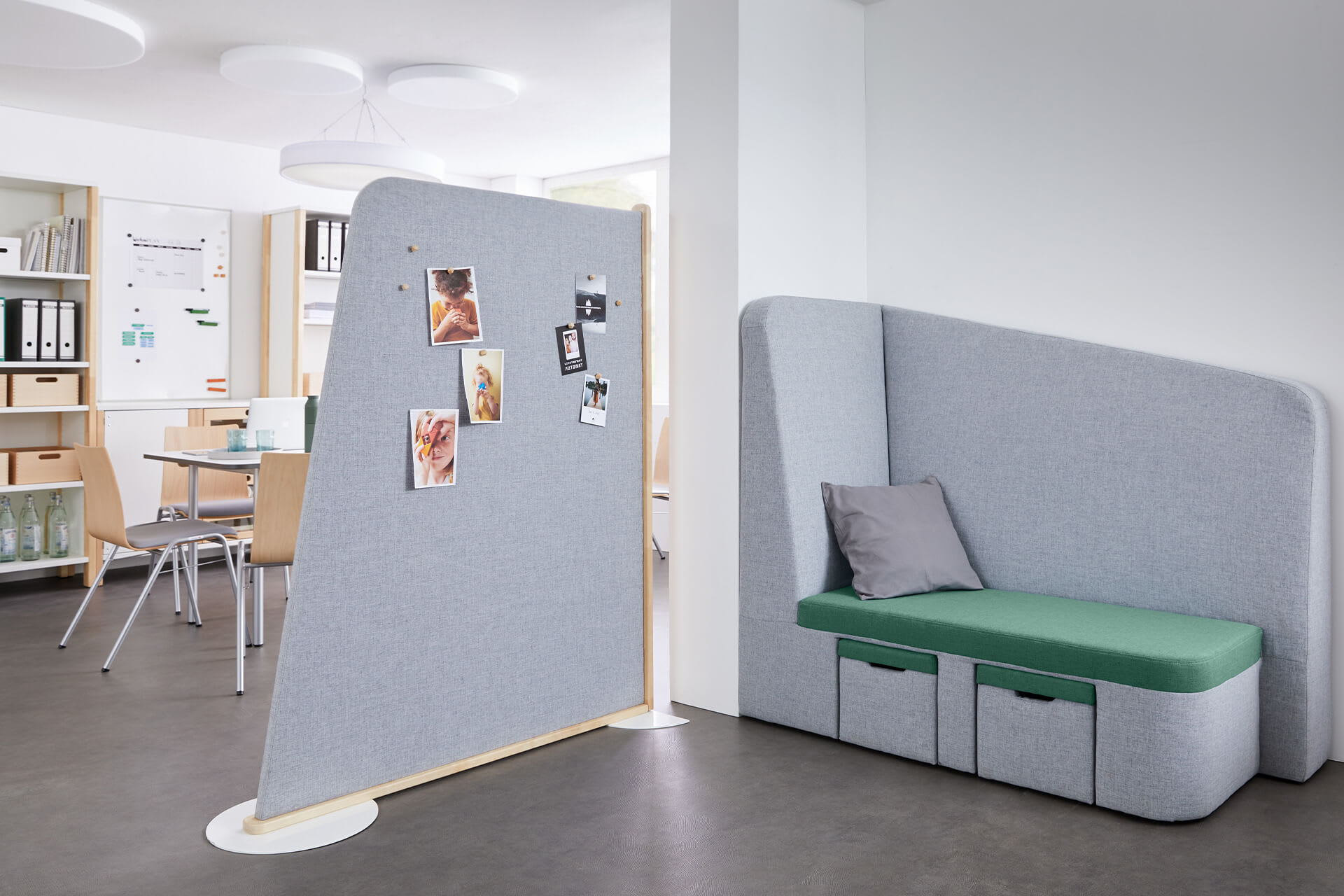  Lernraum | Raumteiler & Präsentationen | Grauer Raumteiler trennt Arbeitsbereich - Tisch mit Stühlen und Schränke, mit Sofa-Ecke in grau und grünem Sitzpolster.