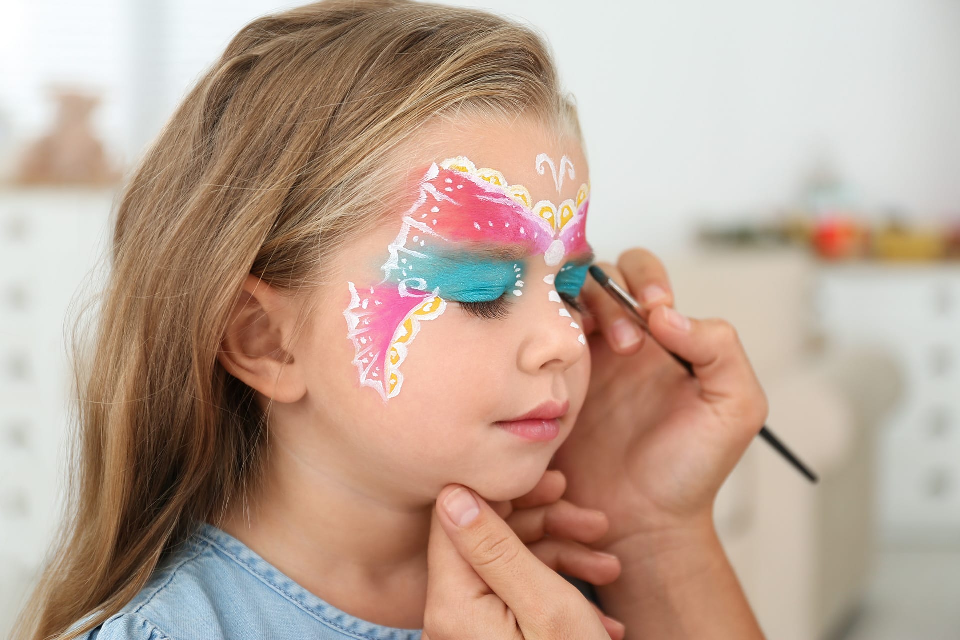 Faschings schminken | Image | Kleines Mädchen wird im Gesicht als Schmetterling geschminkt
