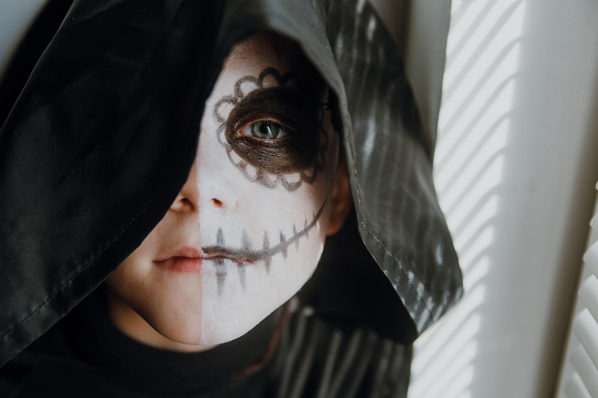 Faschings schminken | Image | Kind mit schwarzer Kapuze und als Skelett geschminktes Gesicht
