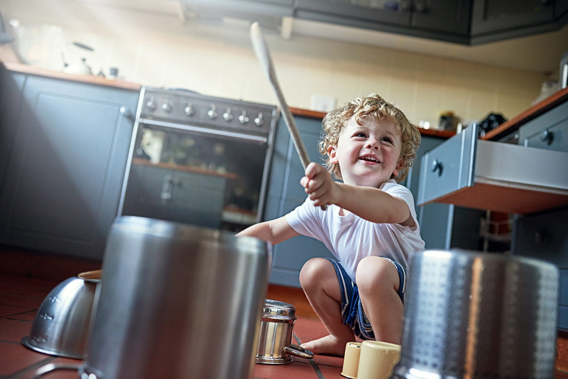 Basteln mit Kindern | Junge trommelt auf umgedrehte Kochtöpfe und Schüsseln, in der Küche