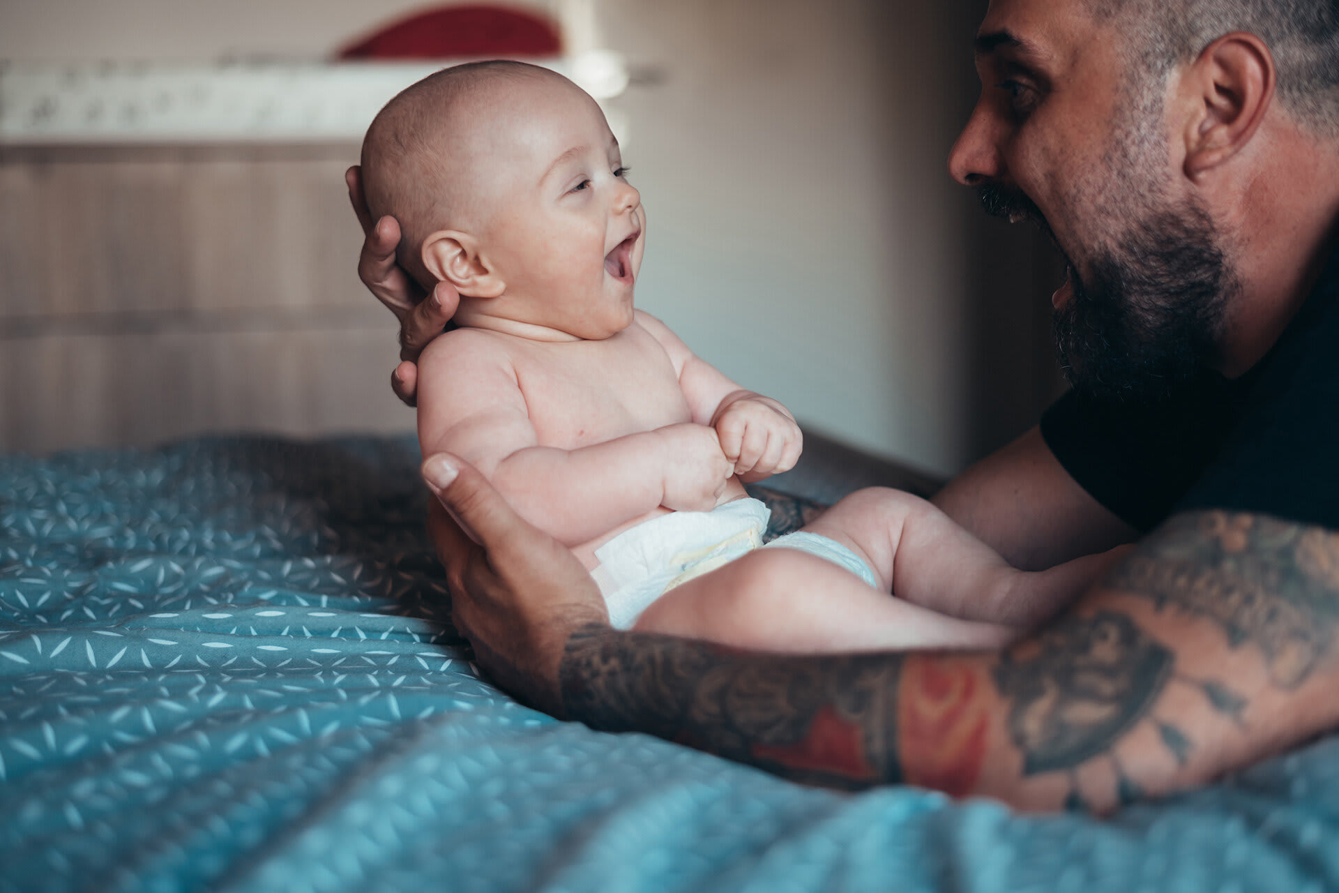 Rituale für Babys & Kleinkinder | Tätowierter bärtiger Vater spielt mit seinem Sohn 