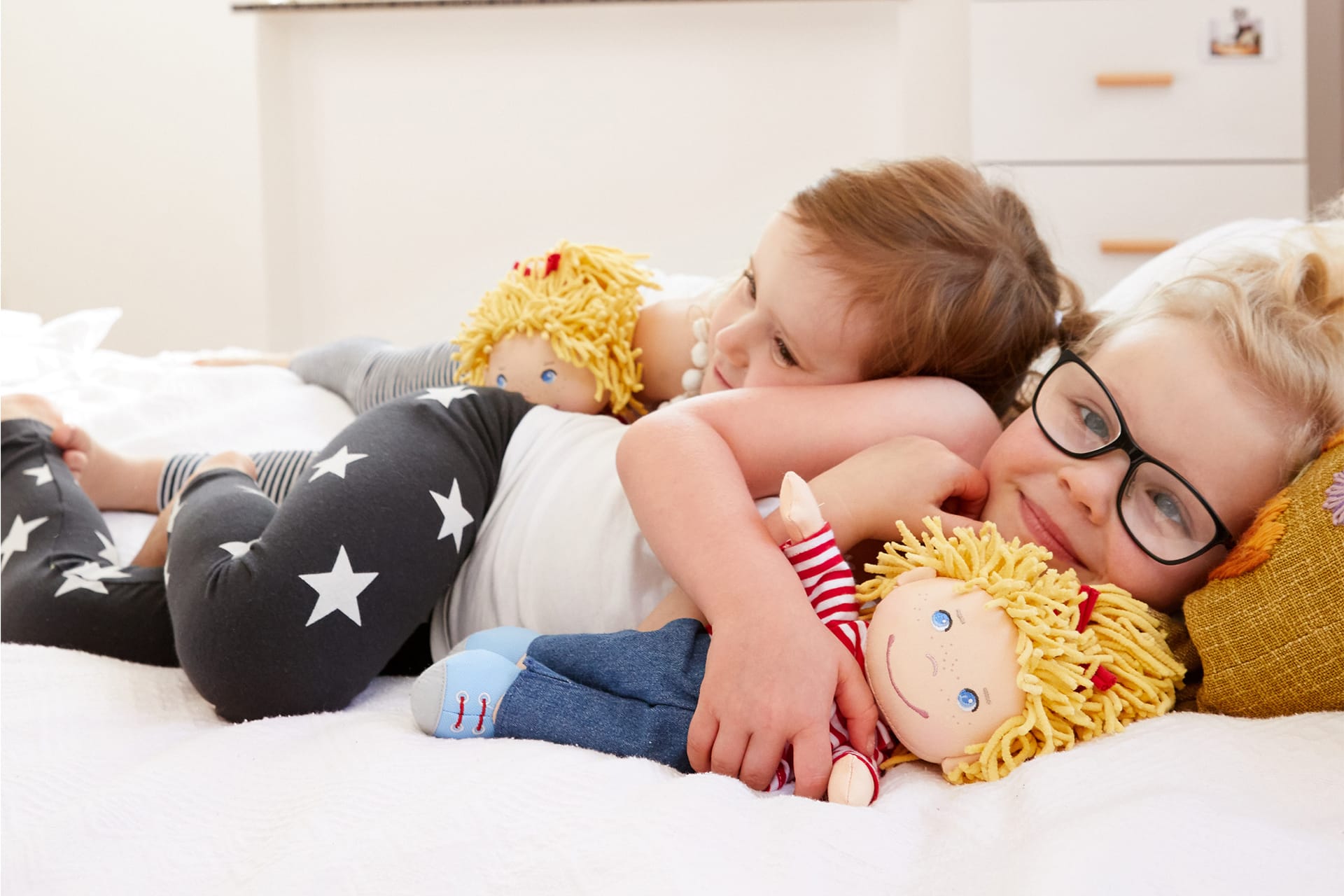  Conni – Das Zirkus-Musical | Kinder liegen mit Conni Puppe von HABA im Bett und kuscheln zusammen