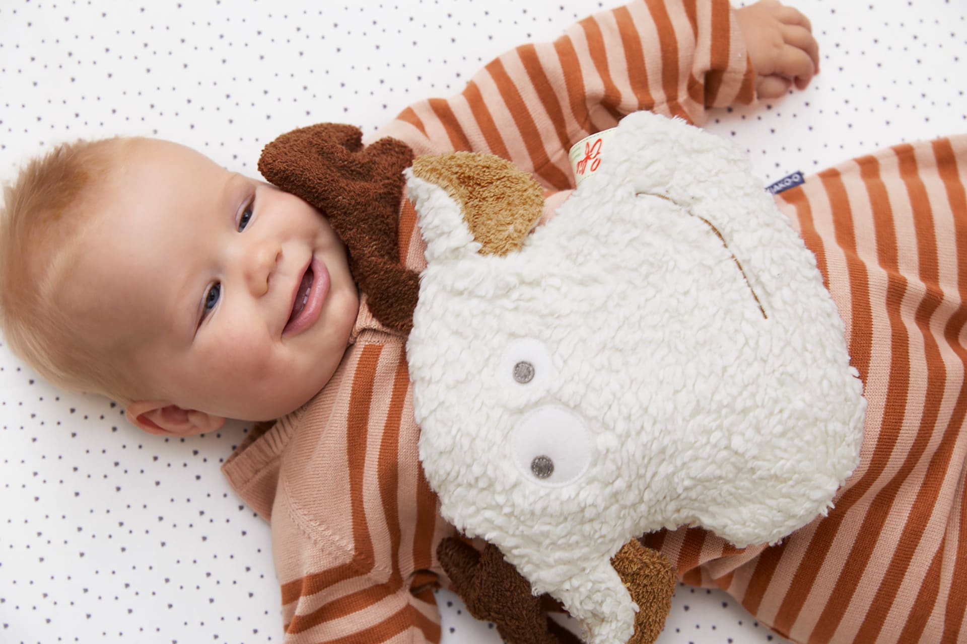 Verstopfung bei Babys | Baby hat ein Kirschkernkissen auf dem Bauch liegen 