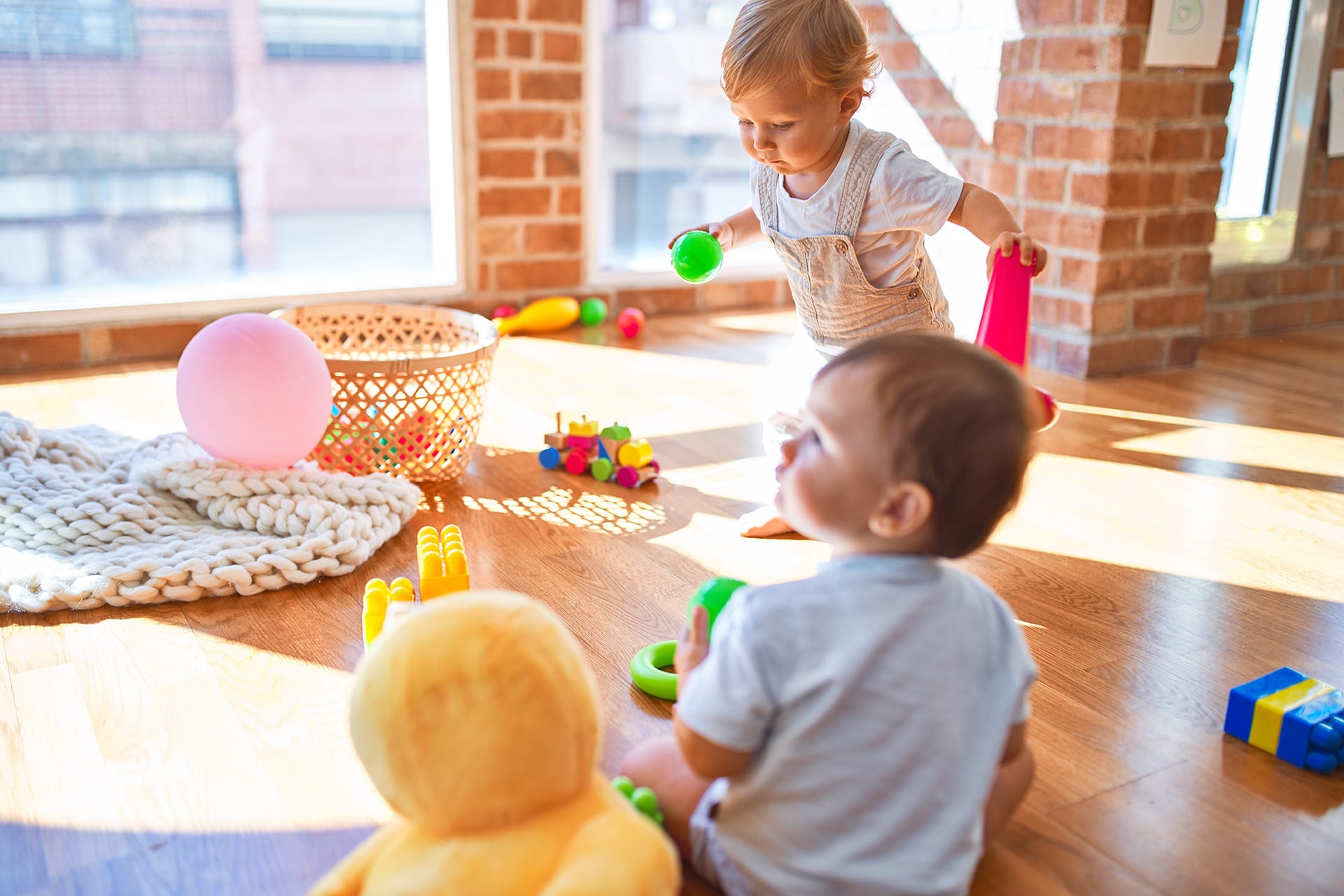 Kindergarten Alter | Zwei Kleinkinder spielen am Boden