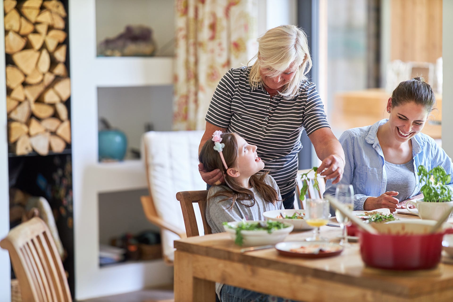 Kindern Tischmanieren beibringen | Familie sitzt am gedeckten Esstisch zusammen