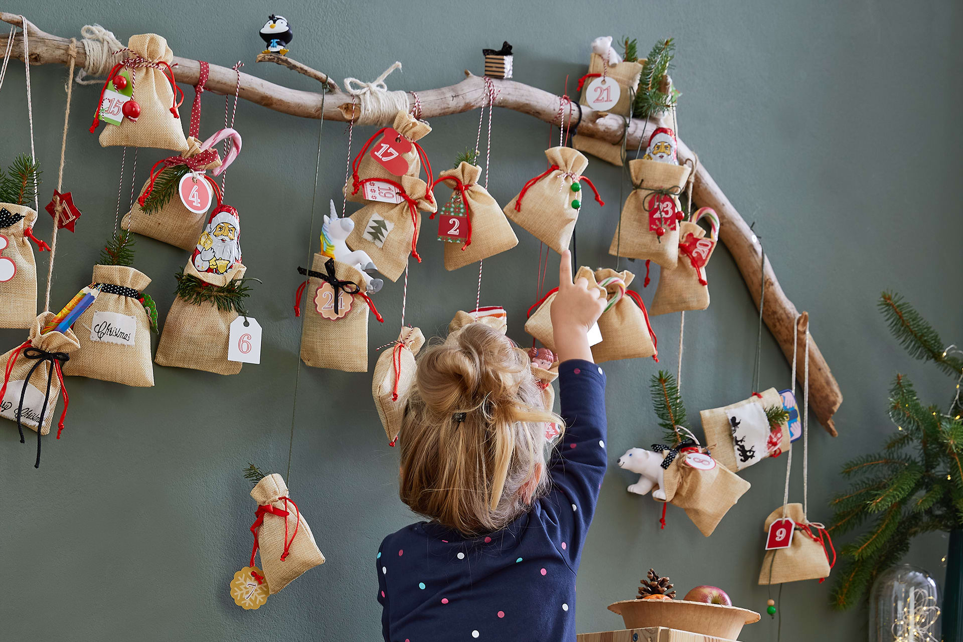 Advent mit Kindern | Kind zeigt auf Adventskalender aus kleinen Säckchen