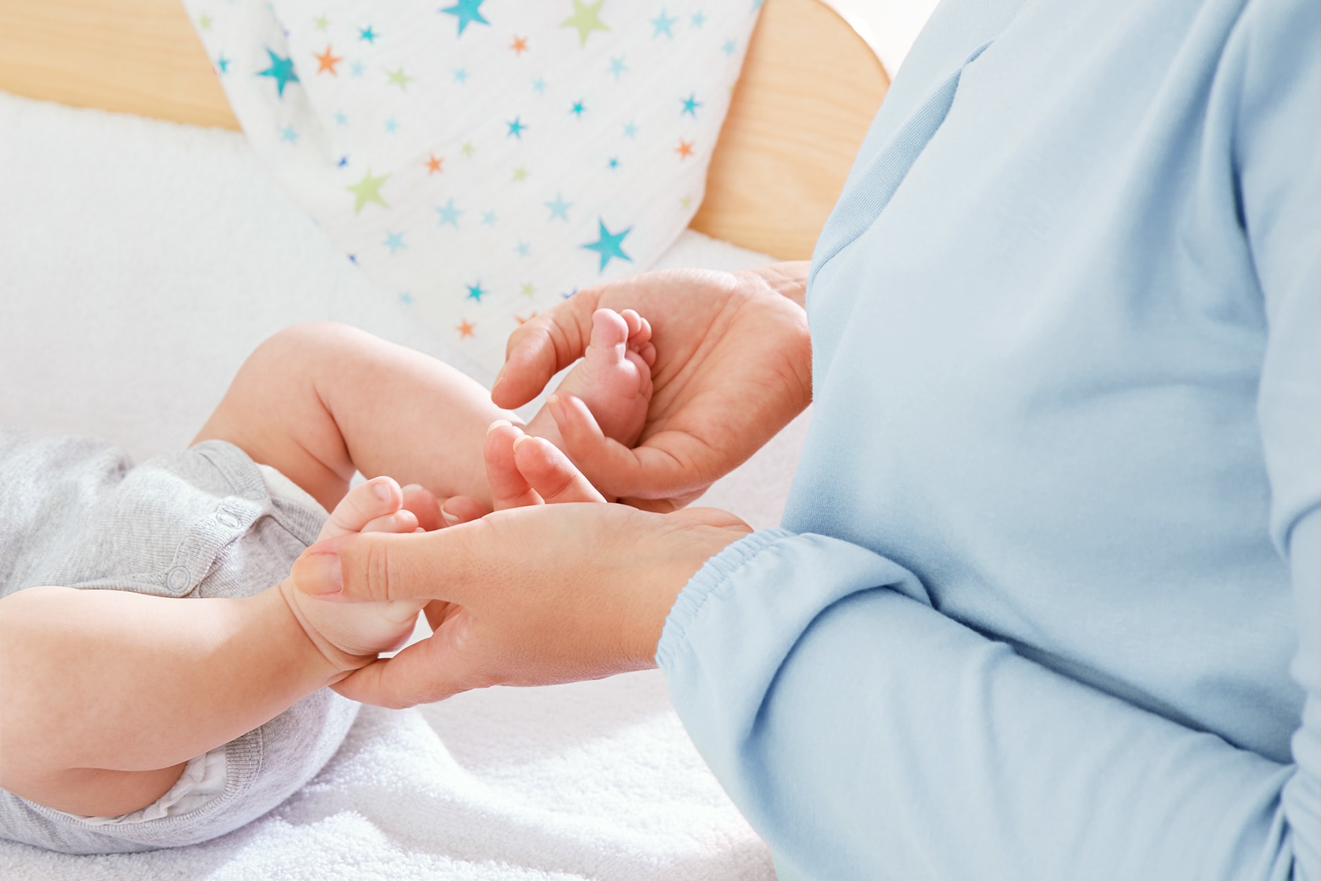 Baby wickeln | Mutter streichelt Babyfüsse auf dem Wickeltisch