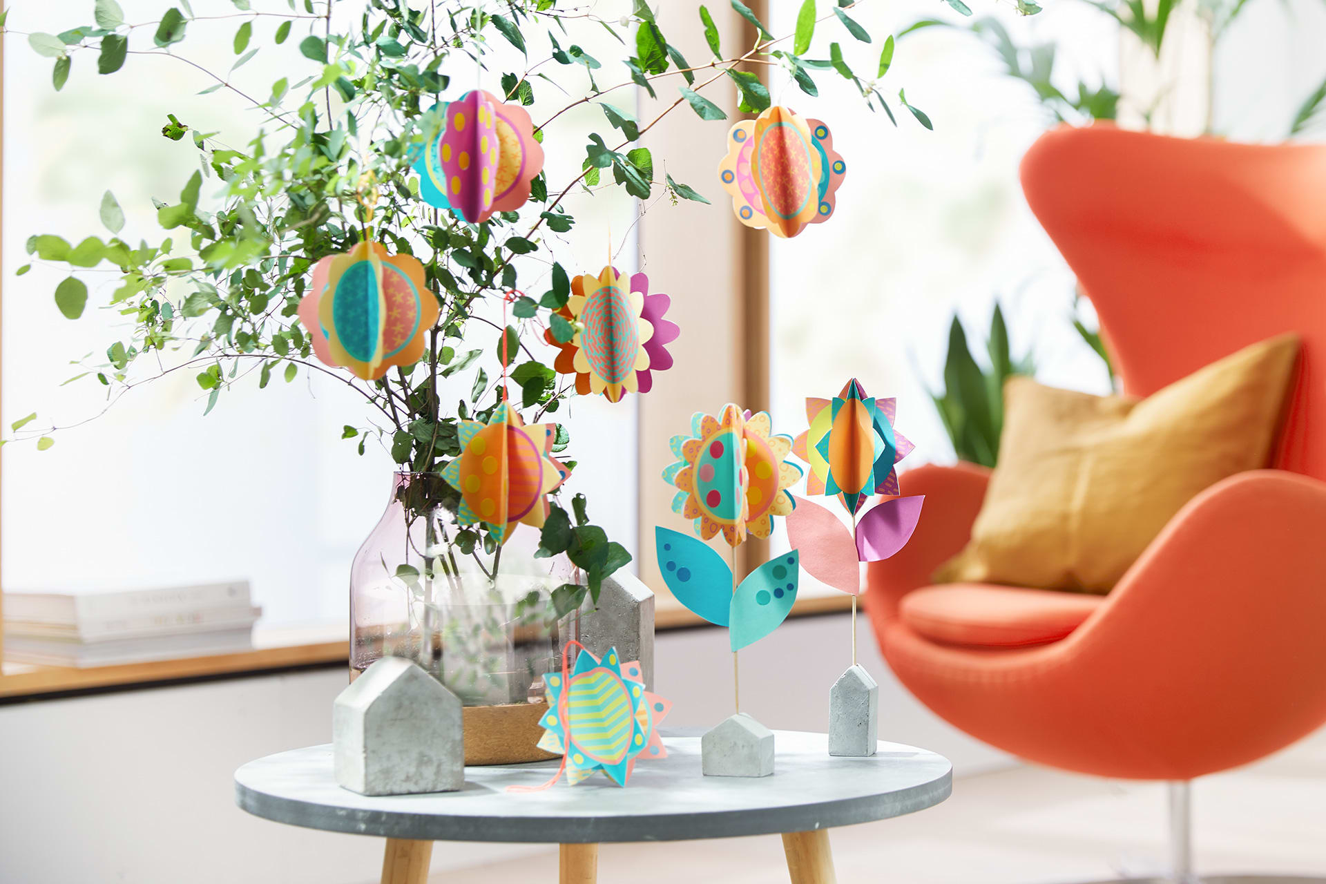  Blumen basteln mit Kindern | Papierblumen hängen an Ästen-Strauß in einer Vase und auf Holzständern.