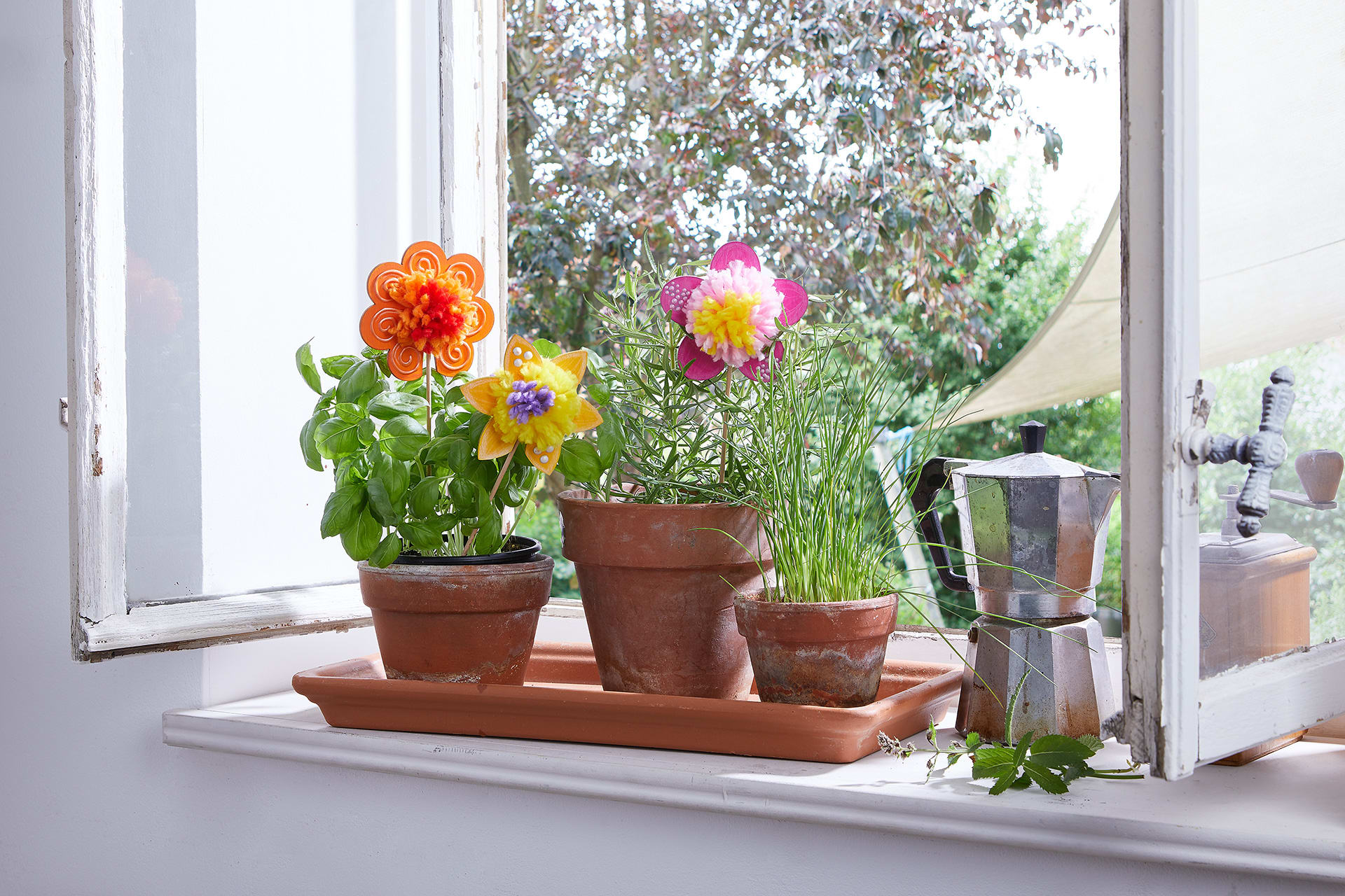  Blumen basteln mit Kindern |  Bunte Blumen aus Kreppapier und Tonpapier stecken in Kräutertöpfen.