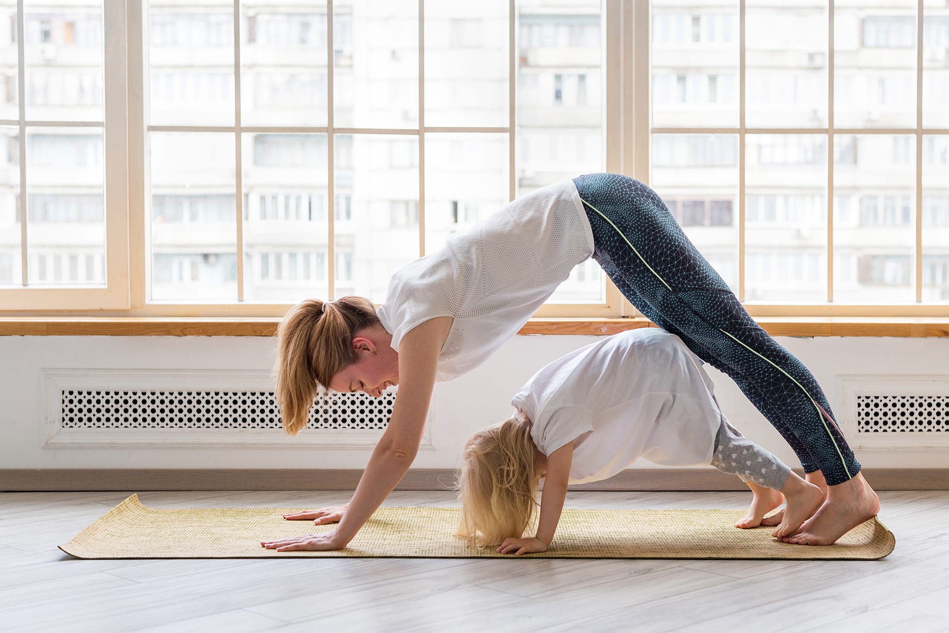 Entspannungsübungen für Kinder | Junge Mutter macht Yoga Hund Asana-Pose
