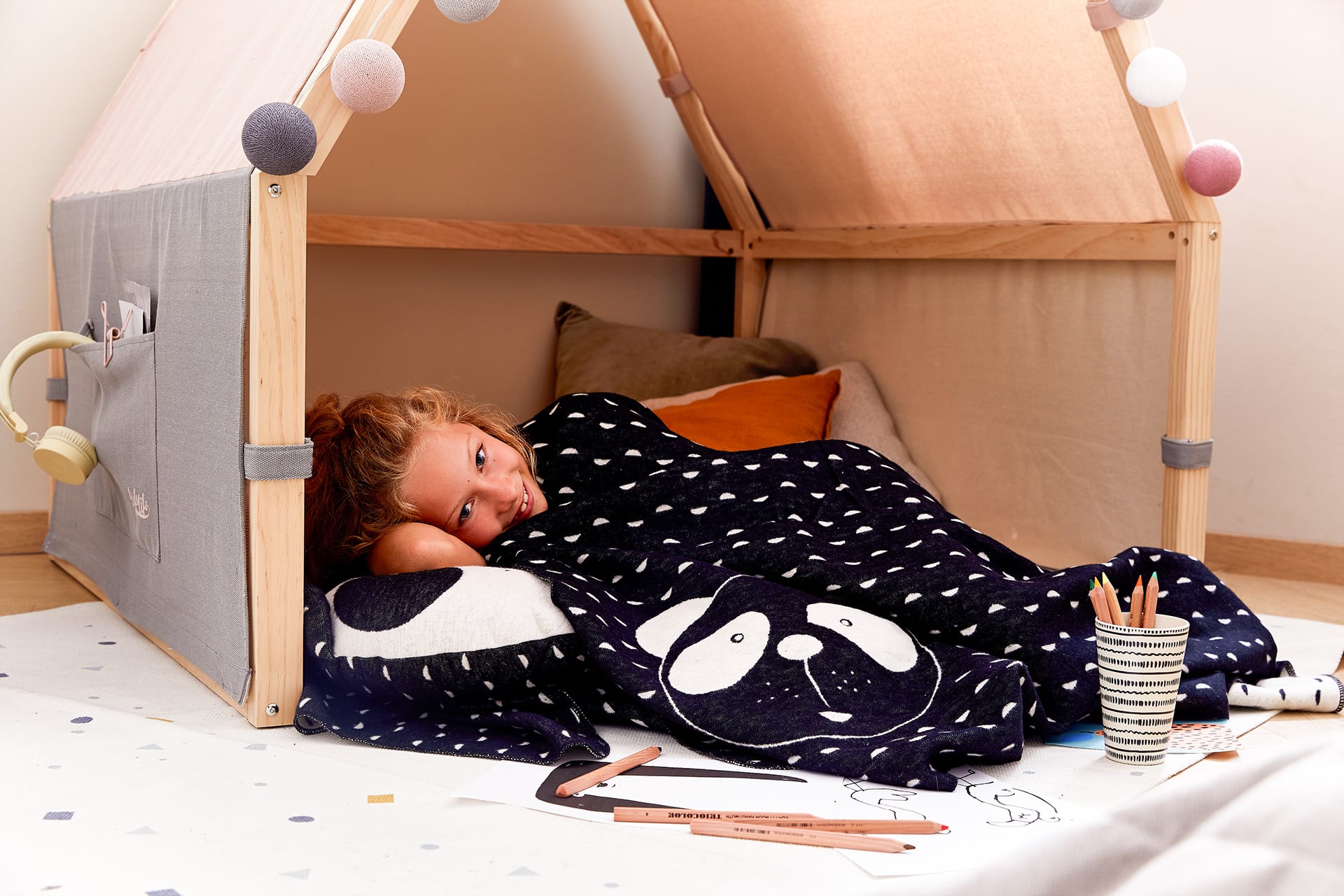 Entspannungsübungen für Kinder | Mädchen mit Pinguin Overall zieht sich in Kuschelhöhle zurück