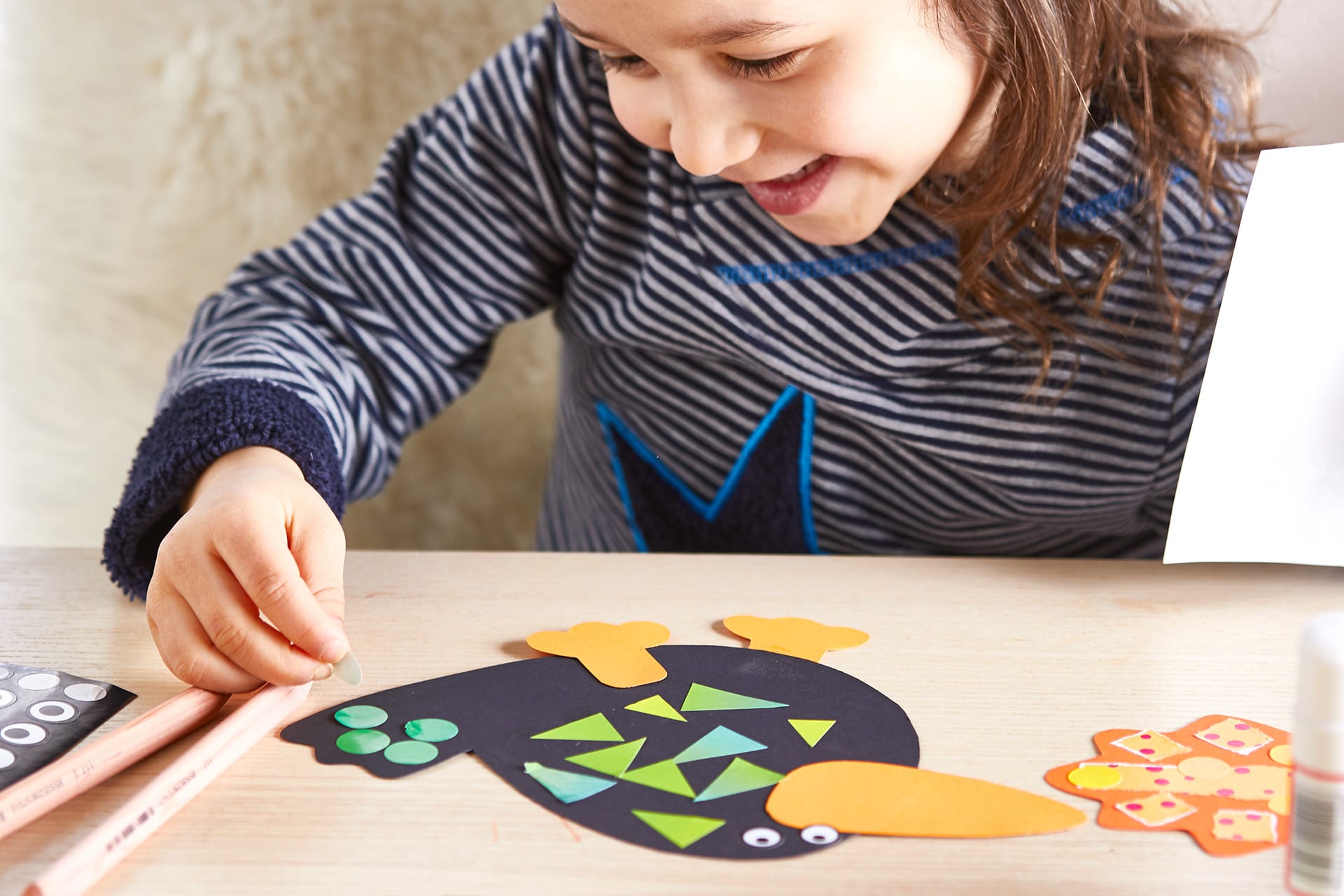  Erstes Basteln für Kinder | Mädchen klebt Schnipsel auf Papierrabe