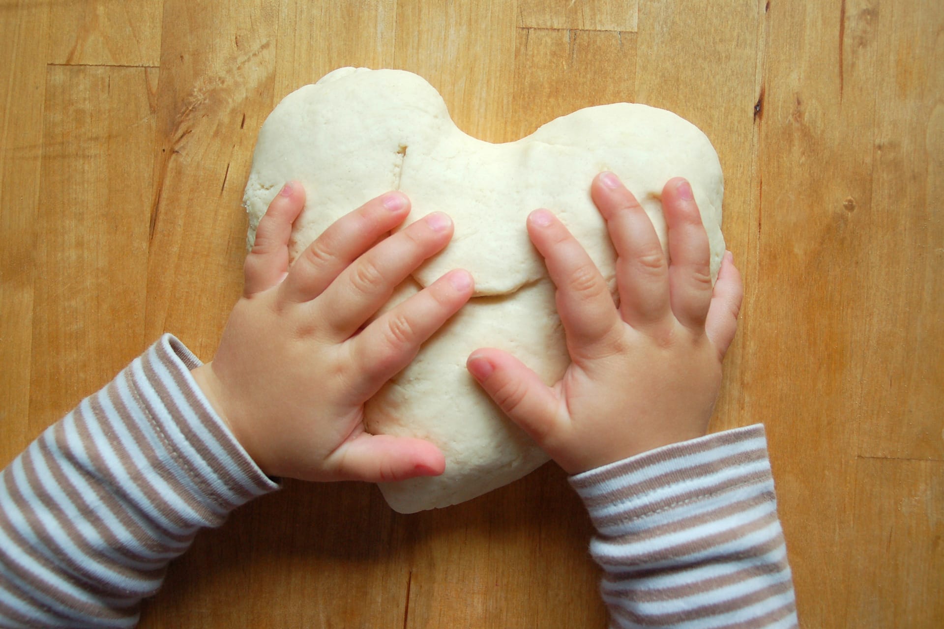  Erstes Basteln für Kinder | Kinderhände mit Teig in Herzform