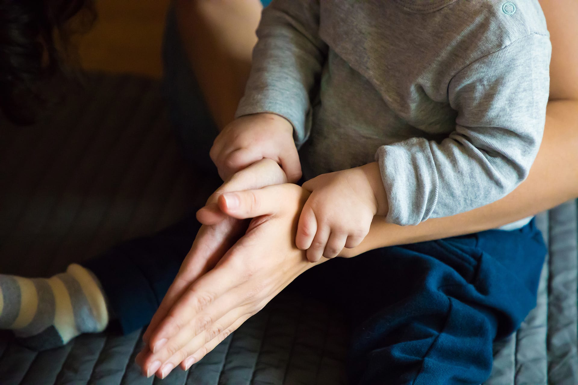 Erzählen für und mit Kindern | Kinderhände liegen auf Elternhände und machen Fingerspiele