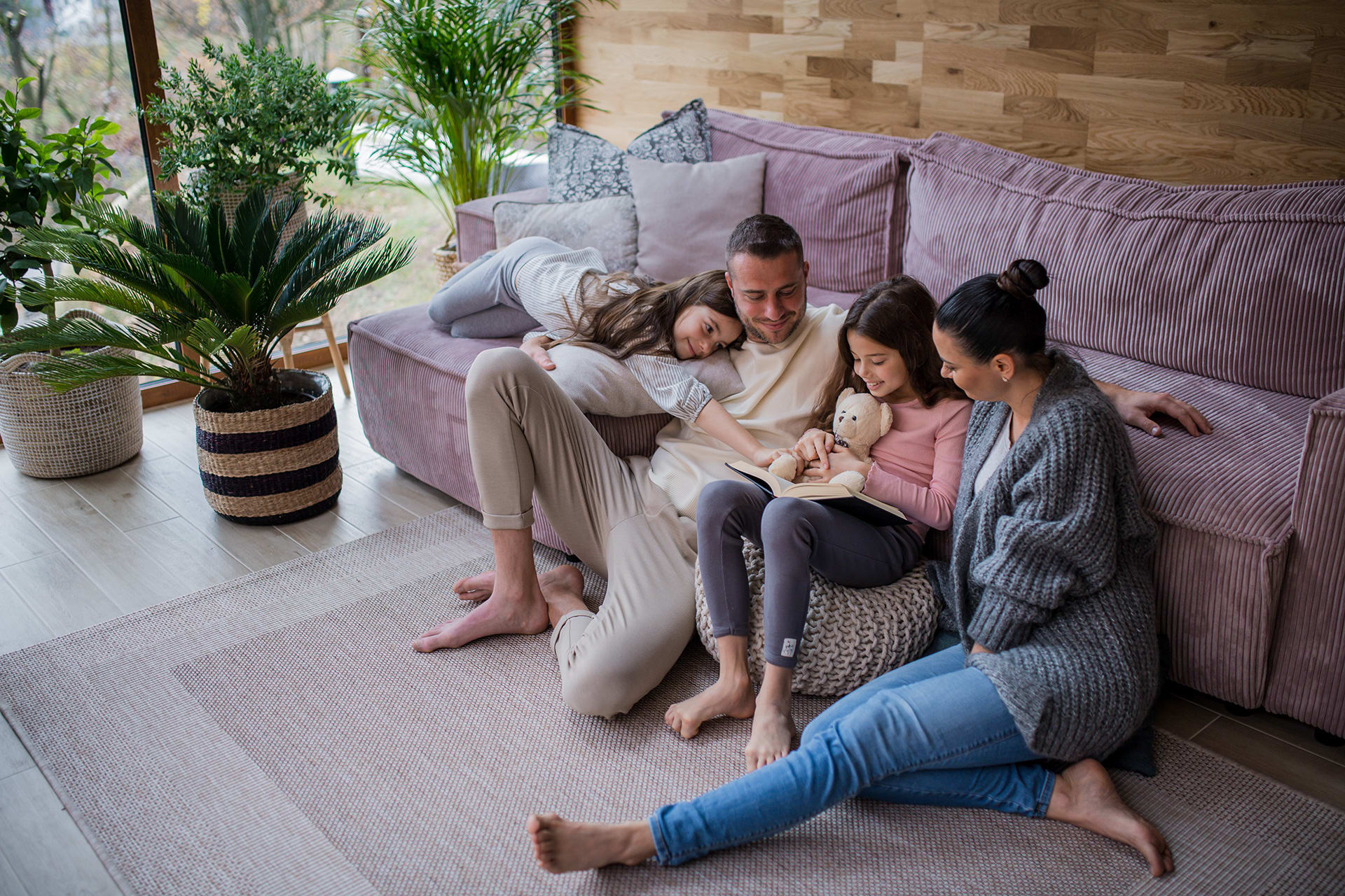 Spielen mit Kindern | Familie sitzt mit Kindern vor dem Sofa
