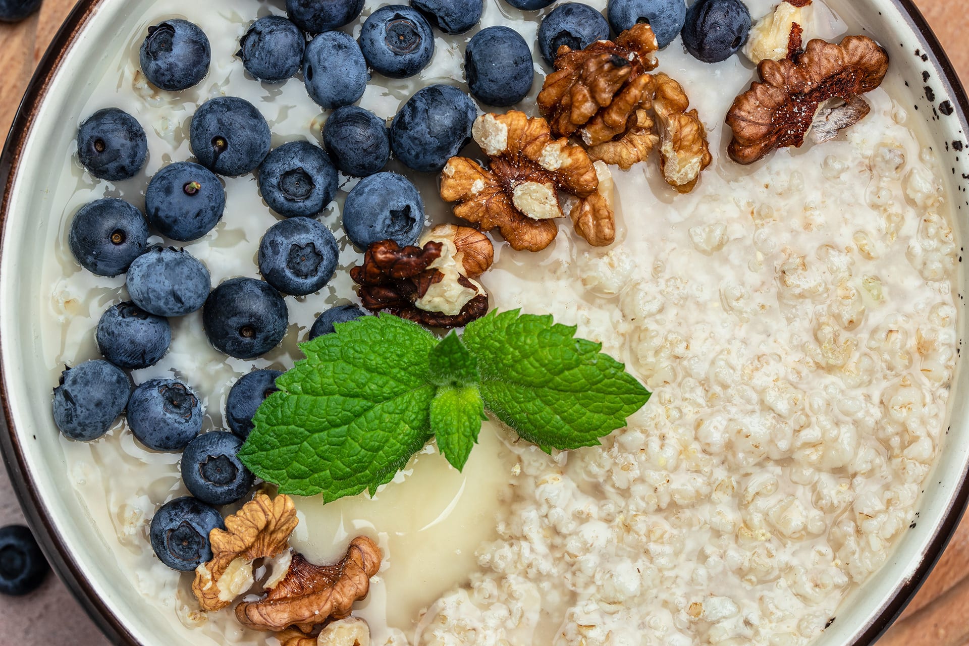  Gesundes Frühstück für Kinder |  Haferflockenbrei mit reifen Heidelbeeren, Nüssen und Honig zum Frühstück