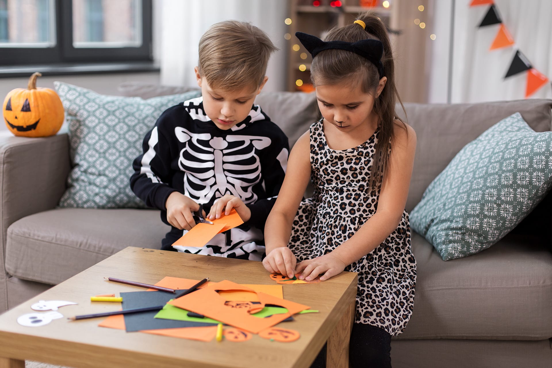 Halloween Masken | Junge und Mädchen basteln für Halloween am Tisch