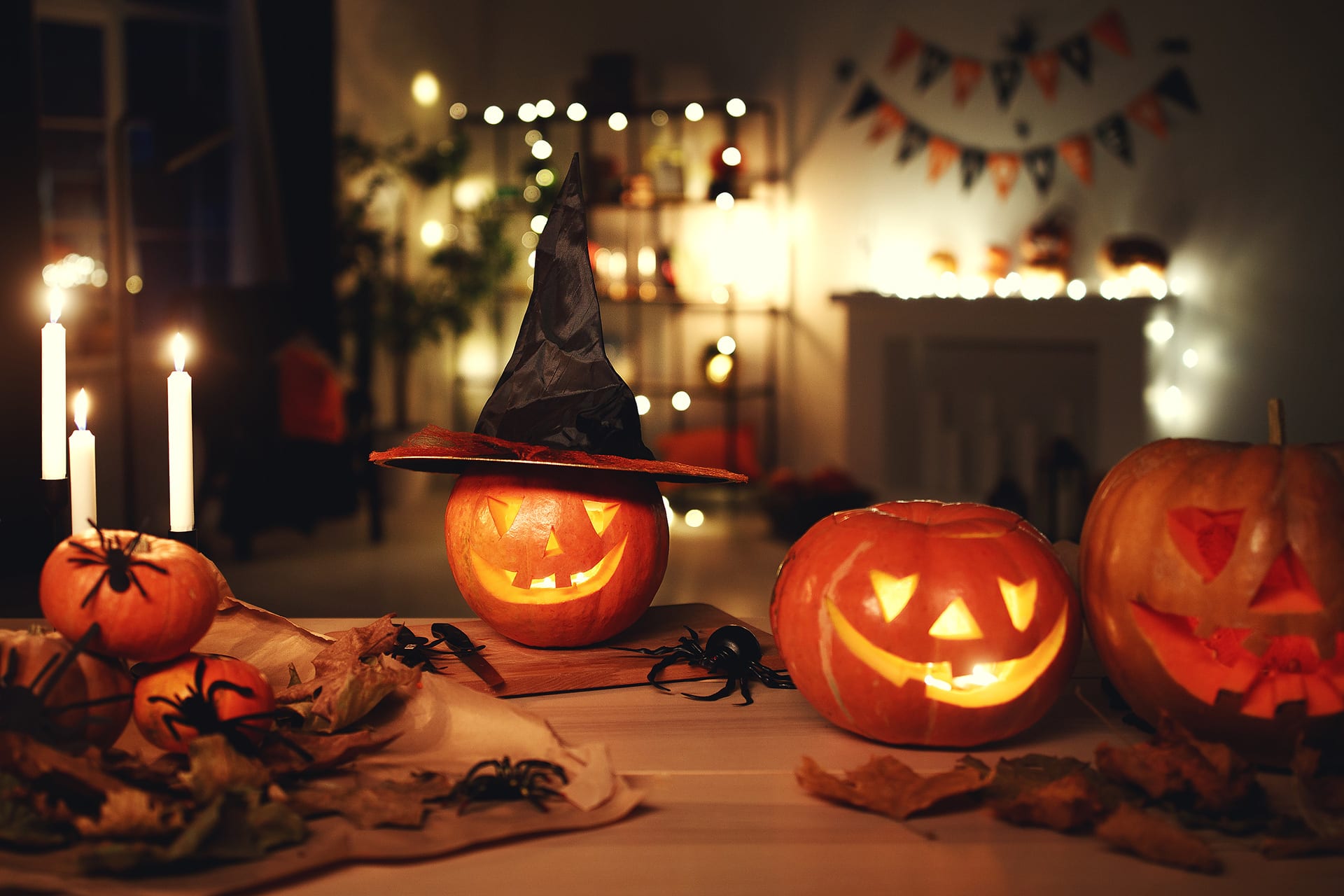 Halloween mit Kindern | Tisch dekoriert mit beleuchteten Kürbisse, Girlanden