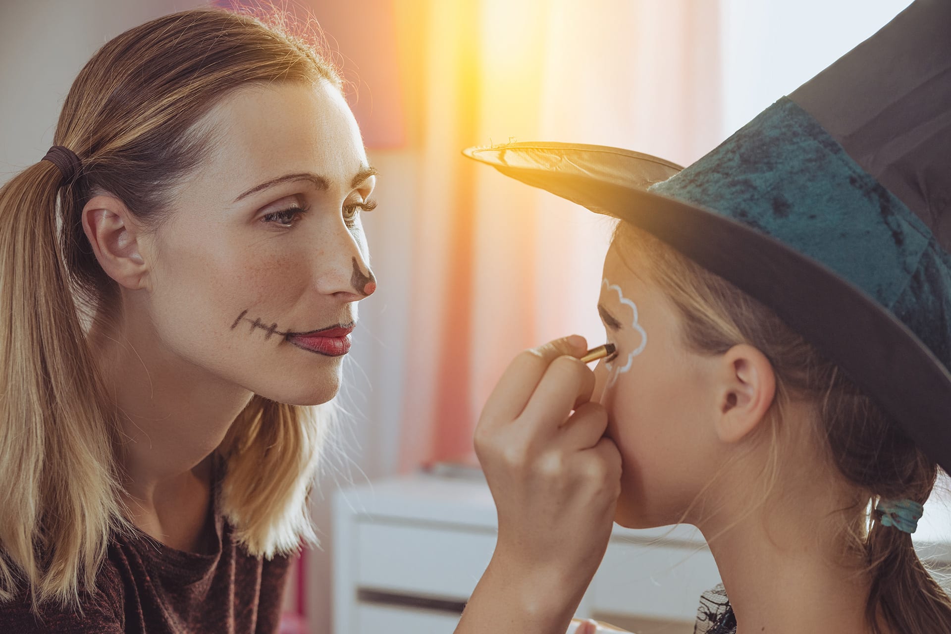 Halloween mit Kindern |  Mutter schminkt Tochter mit Halloween-Motiven