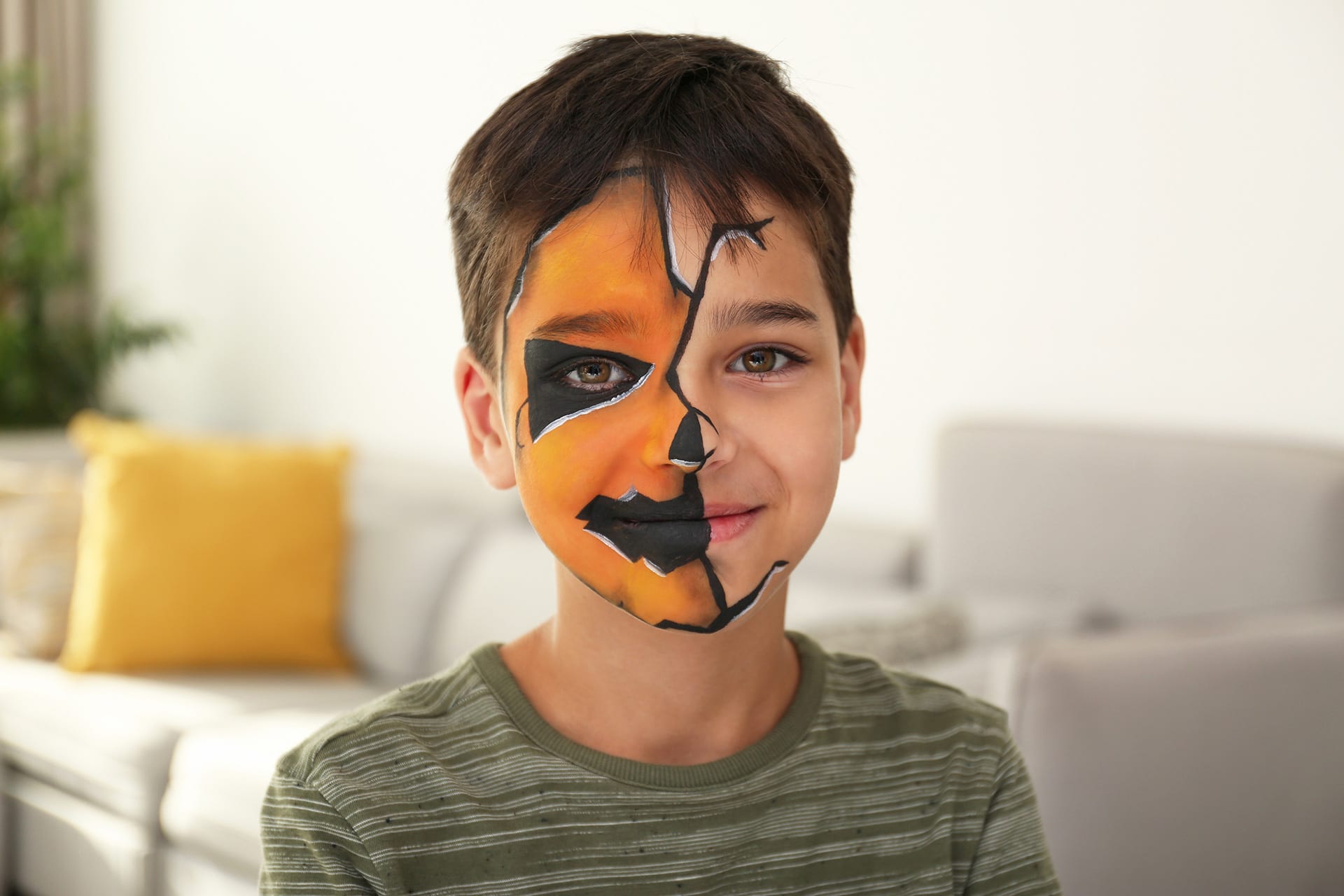 Halloween schminken | Junge im Gesicht als Halloween-Kürbis geschminkt