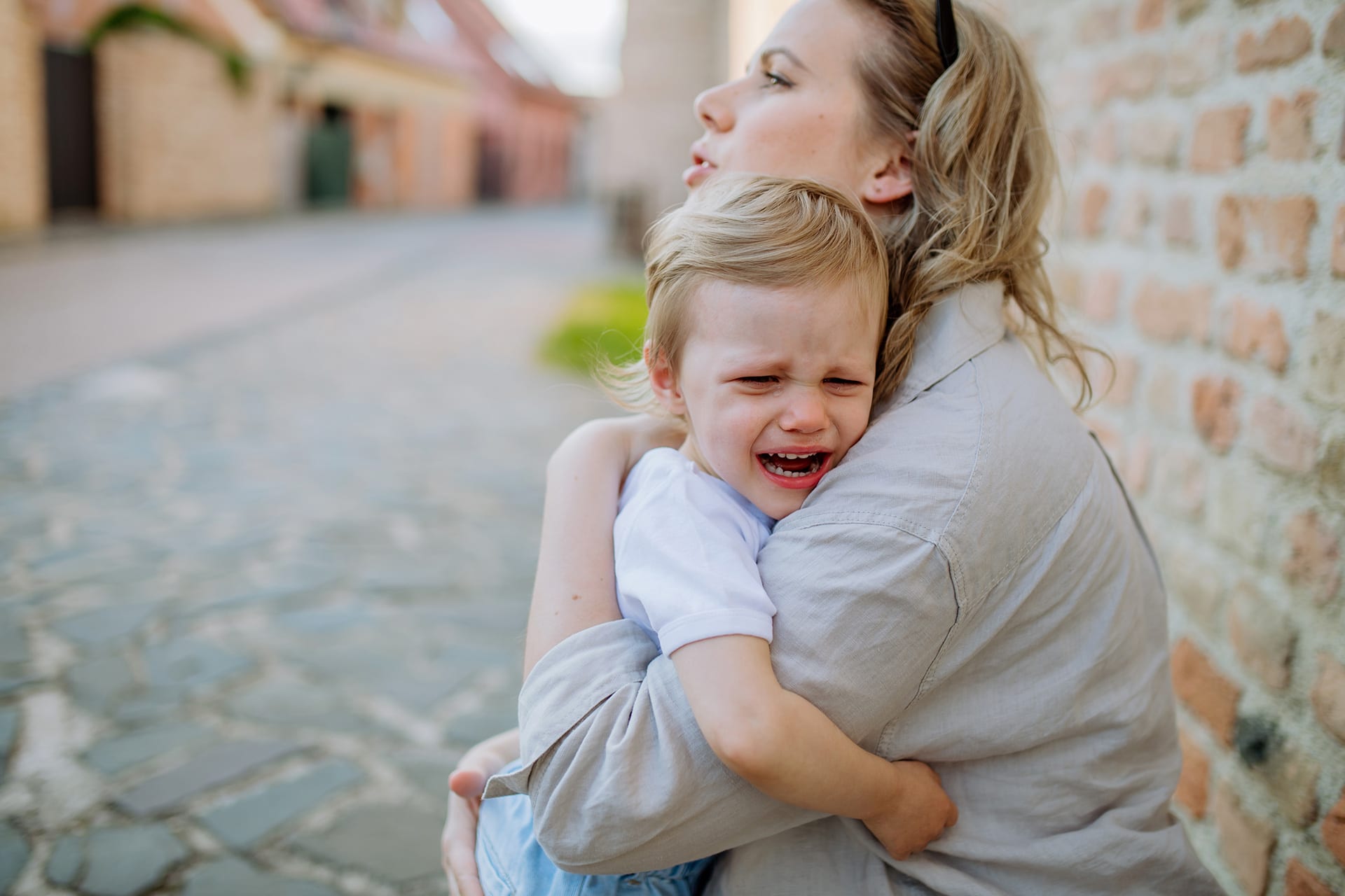 Trennungsangst bei Kindern | Kind liegt weinend in dem Arm von der Mutter