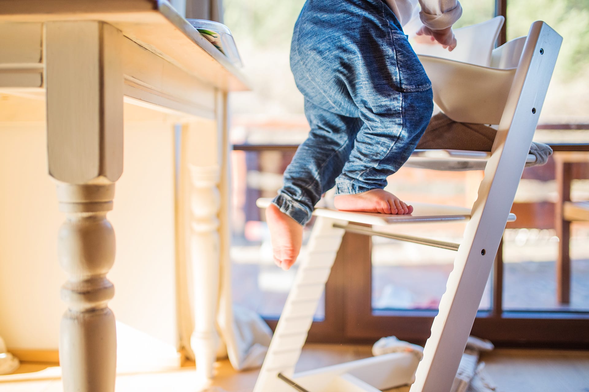 Kindersicherheit Zuhause | Baby klettert auf Tripp-Trapp-Stuhl