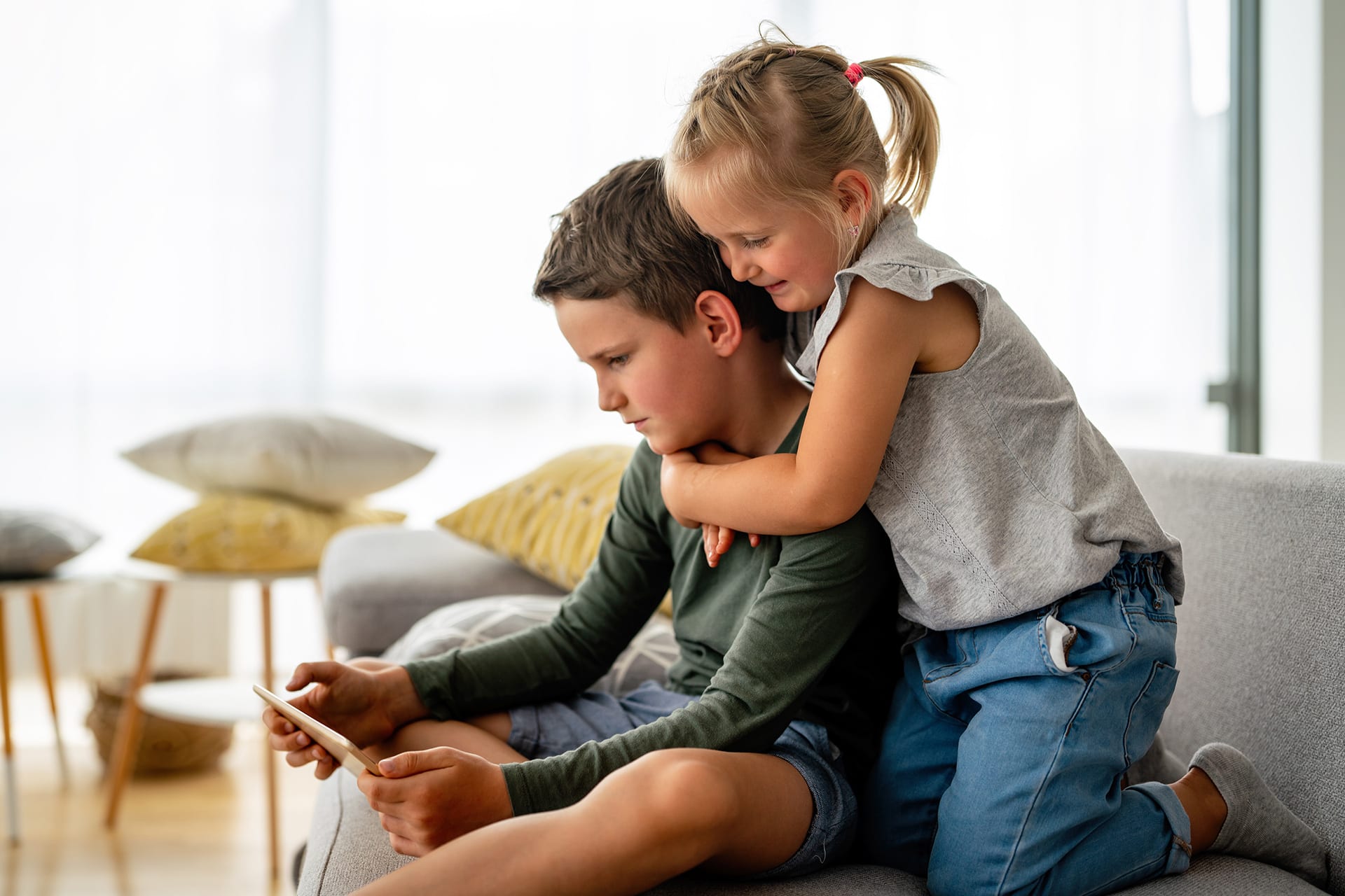 Kinder Digitale Medien | kleines Mädchen und ein Junge sehen sich ein Video an oder spielen Spiele auf ihrem digitalen Gerät (Tablet, Smartphone).