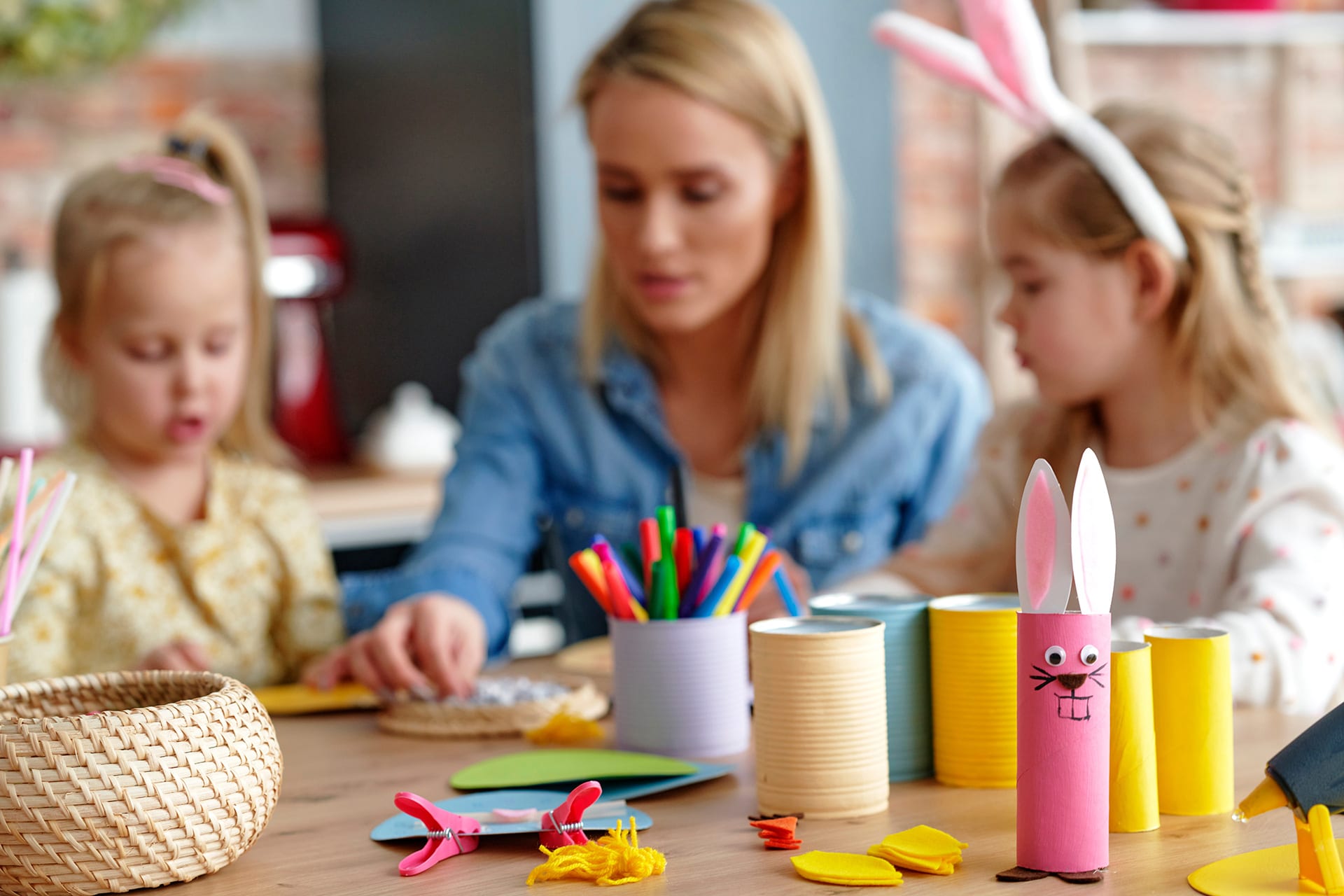 Basteln mit Kindern | Mutter bastelt mit Töchtern Osterhasen aus Tonkarton am Tisch