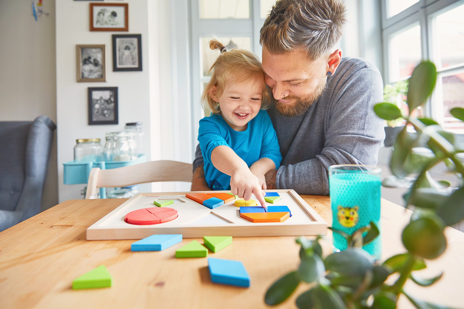 Warum spielen wichtig ist | Vater spielt mit blonden Mädchen ein Holzlegespiel