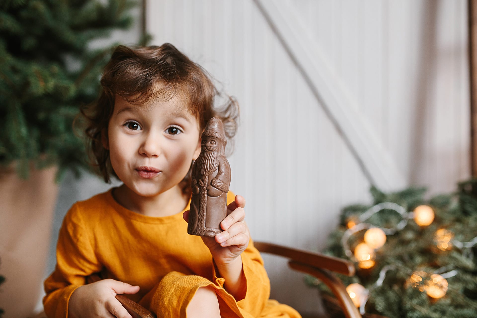Adventskalender basteln | Mädchen hält Schokoladen-Nikolaus hoch