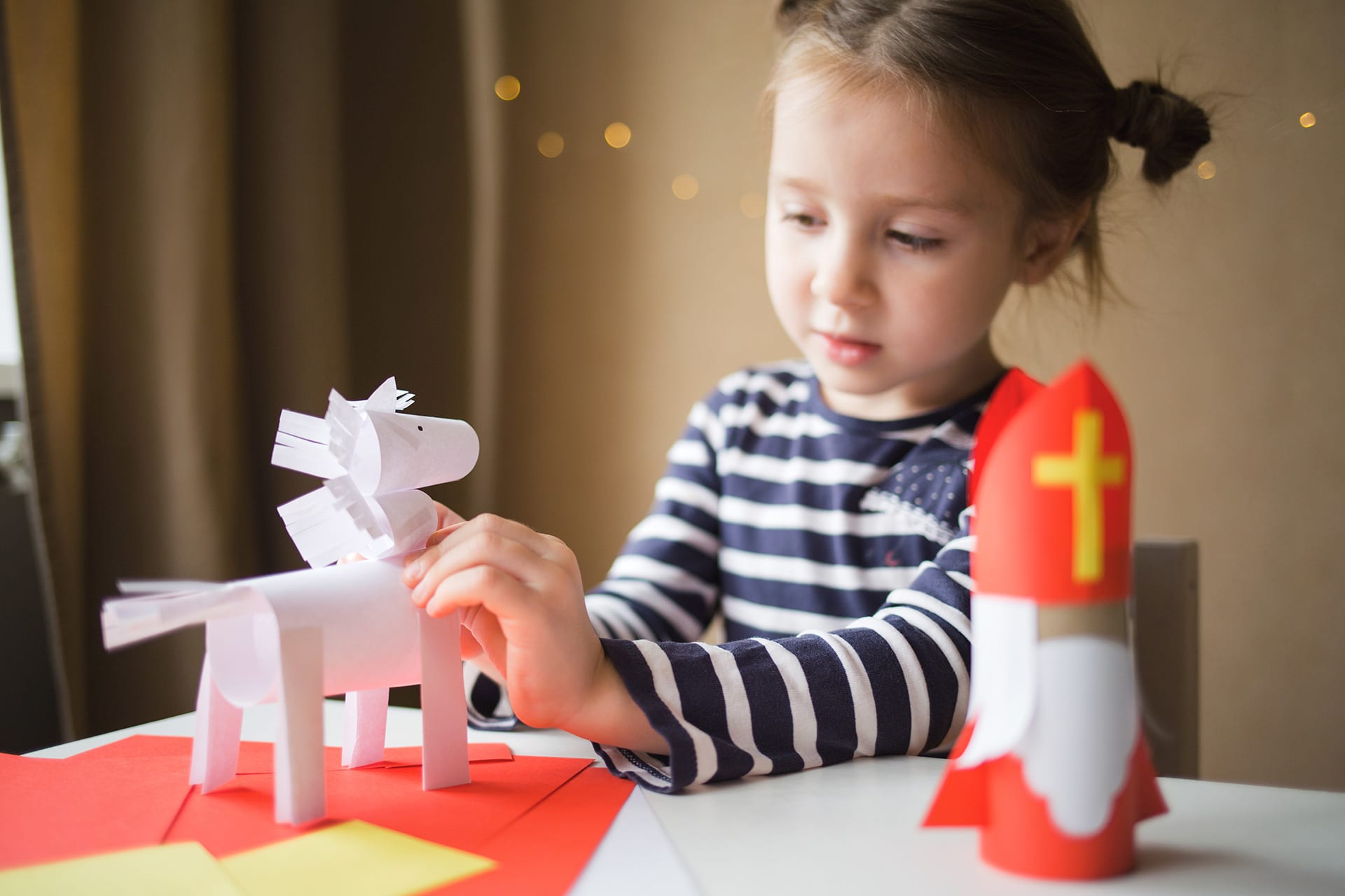 Advent mit Kindern | Mädchen bastelt Nikolaus und Pferd aus Tonpapier