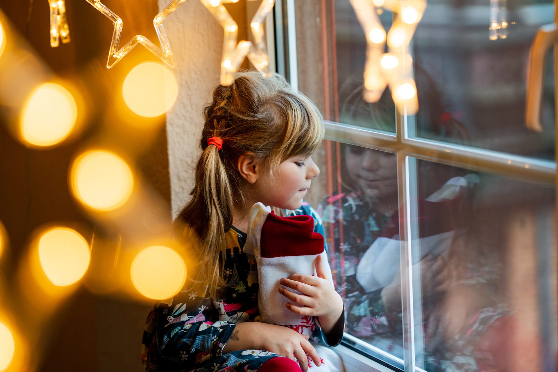 Nikolaus Kindern erklären | Kind am Fenster mit Nikolausstiefel