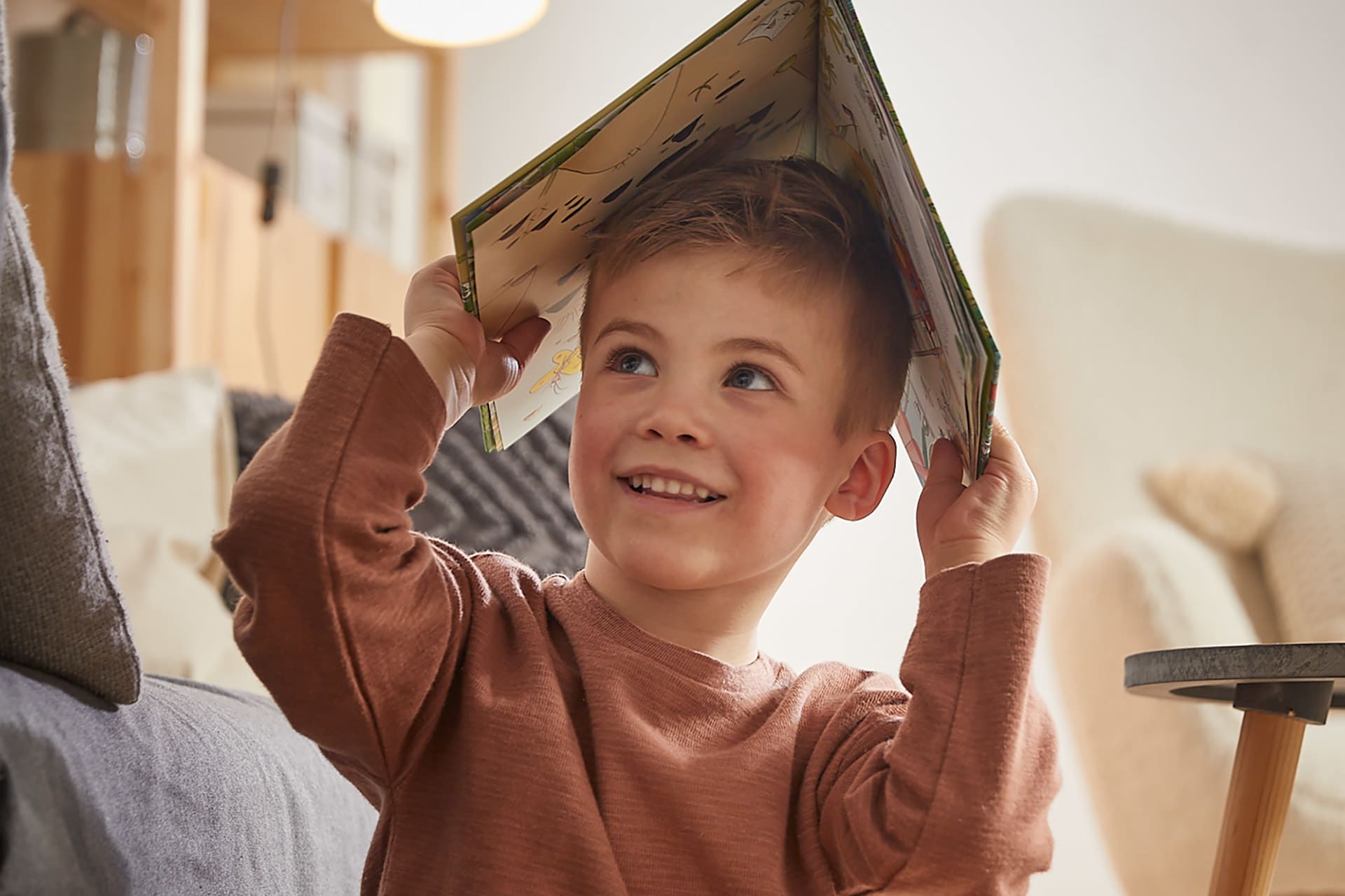 Bedeutung des Vorlesens | Junge hält Buch über den Kopf
