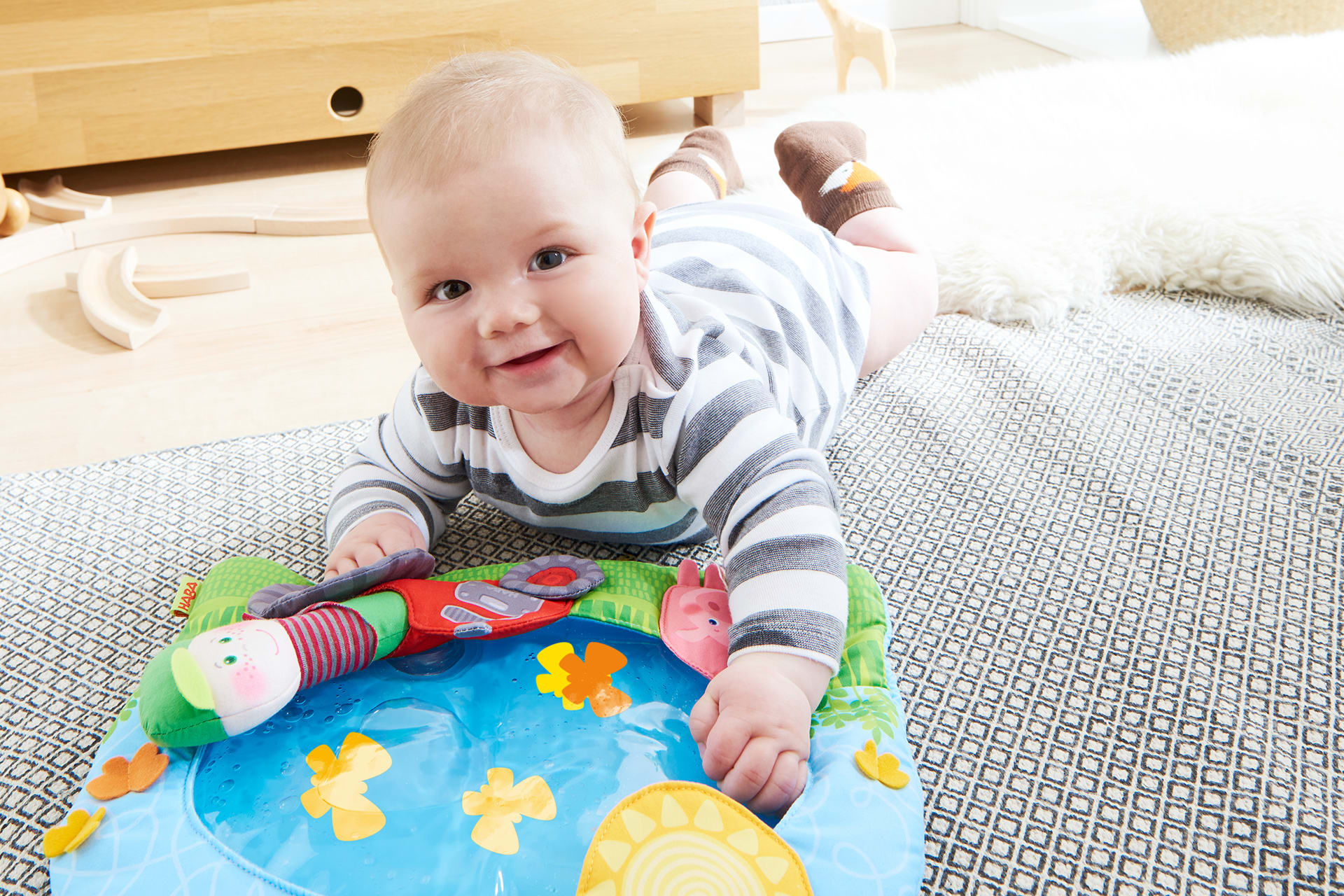 HABA Wasser-Spielmatten | Baby liegt auf dem Bauch und spielt mit Wasserspielmatte 