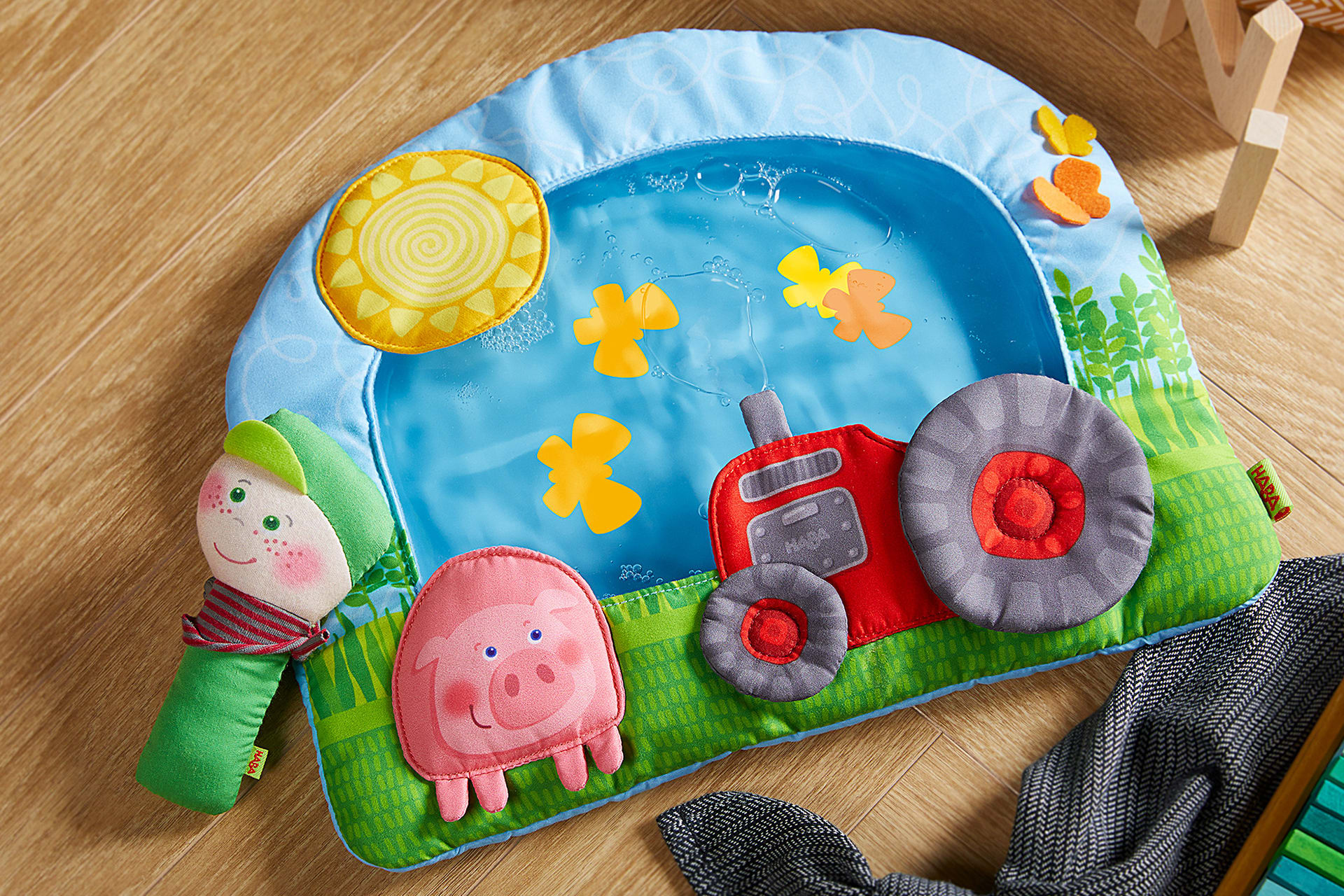 HABA Wasser-Spielmatten | Freistellerbild mit Wasserspielmatte wo ein Schwein, Traktor, Sonne aufgenäht sind