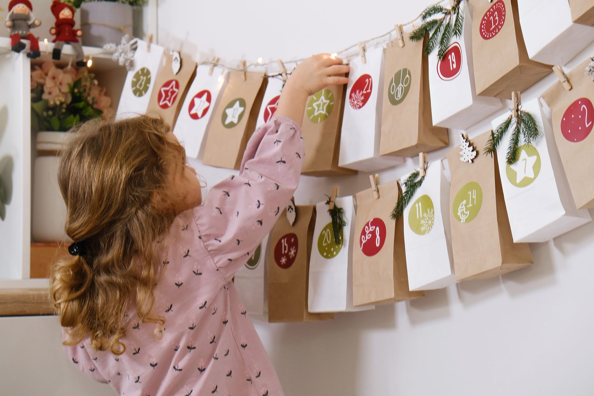 Adventskalender basteln | Kind öffnet Türchen am selbst gemachten Adventskalender