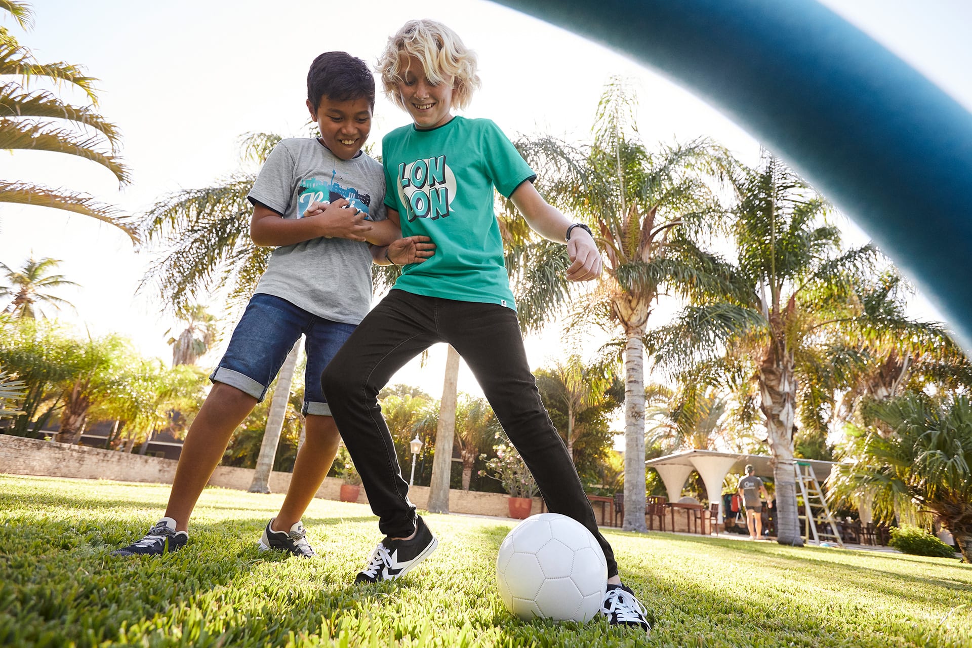 Hobbys für Kinder finden | 2 Jungs spielen unter Palmen mit einem weißen Ball