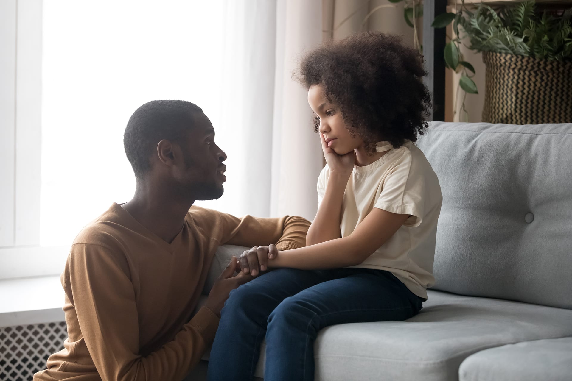 Mit Kindern über Gefühle sprechen | Vater spricht mit seiner Tochter, sitzen auf dem Sofa